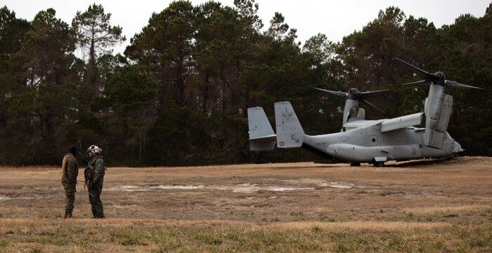 Cpl. Joseph Hernendez, a landing support specialist with 2nd Marine Logistics Group (Forward), speaks with an air crewman during an exercise aboard Camp Lejeune, N.C., Jan. 7, 2011. The exercise consisted of a five to six-man team hooking imitation cargo to a MV-22 Osprey and waiting for its return to the drop zone so they could unhook the cargo, which simulates exporting and importing external lifts. (U.S. Marine Corps photo by Pfc. Franklin E. Mercado)