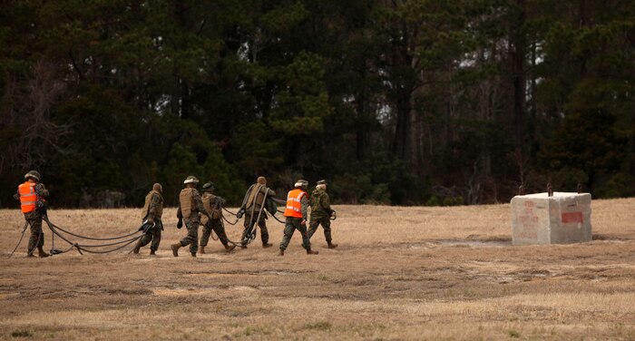 Landing support specialists with 2nd Marine Logistics Group (Forward) attach a suspension cord to a large boulder during an exercise aboard Camp Lejeune, N.C., Jan. 7, 2011. The boulder was supposed to simulate cargo that would be moved to a different location during an external resupply mission. (U.S. Marine Corps photo by Pfc. Franklin E. Mercado)