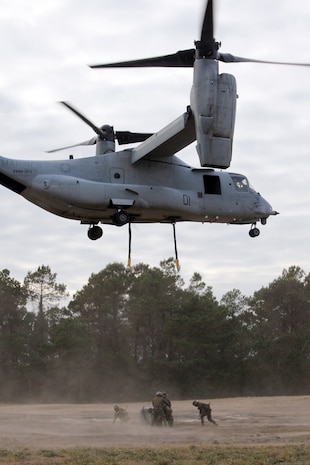 Landing support specialists with 2nd Marine Logistics Group (Forward) try to hook a large bolder to a MV-22 Osprey during an exercise aboard Camp Lejeune, N.C., Jan. 7, 2011. The boulder was supposed to simulate cargo that would be moved to a different location during an external resupply mission. (U.S. Marine Corps photo by Pfc. Franklin E. Mercado)