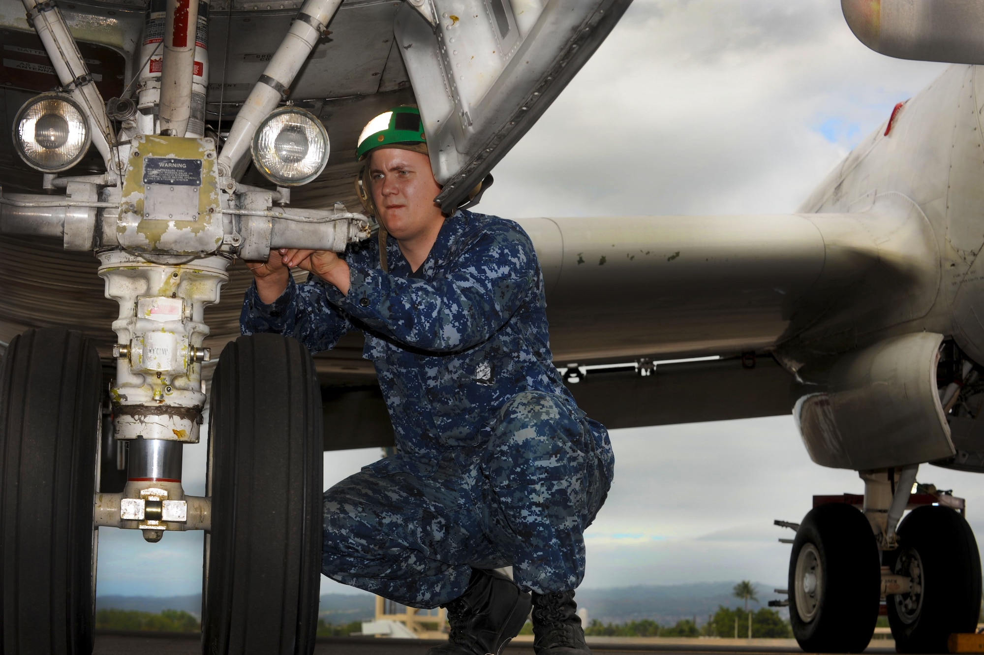 U.S. Navy Airman Joseph Hays checks the safety wiring on the nose landing gear on a P-3 Orion aircraft on the 15th Wing flightline Jan. 6.  The aircraft are temporarily being housed by the 15th Wing due to runway construction at Marine Corps Base Hawaii. The P-3s were initially released to the Navy in 1962 and are used to detect enemy submarines and aircraft. They are also used to view battlespace in order to relay information instantaneously to ground troops. (U.S. Air Force Photo/Airman 1st Class Lauren Main)
