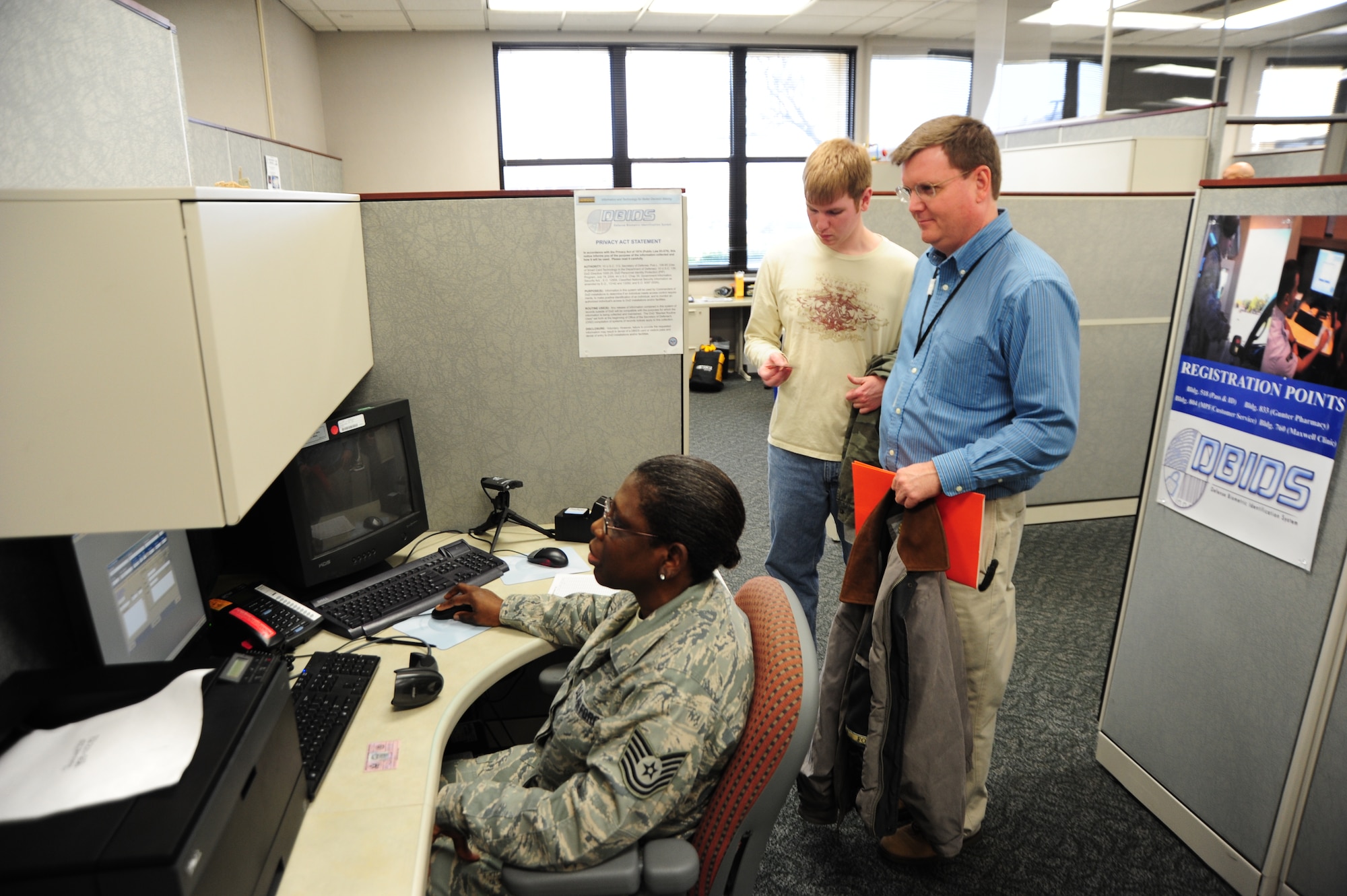 Tech. Sgt. Linnette Clarke, personnelist, 908th Force Support Squadron, registers Mark Vansandt and Nicholas Vansandt in the Defense Biometric Identification System Jan 5. DBIDS will be used to enhance the entry control process. Everyone who requires access to the base is required to register. (Air Force photo/Airman 1st Class Christopher Stoltz)
