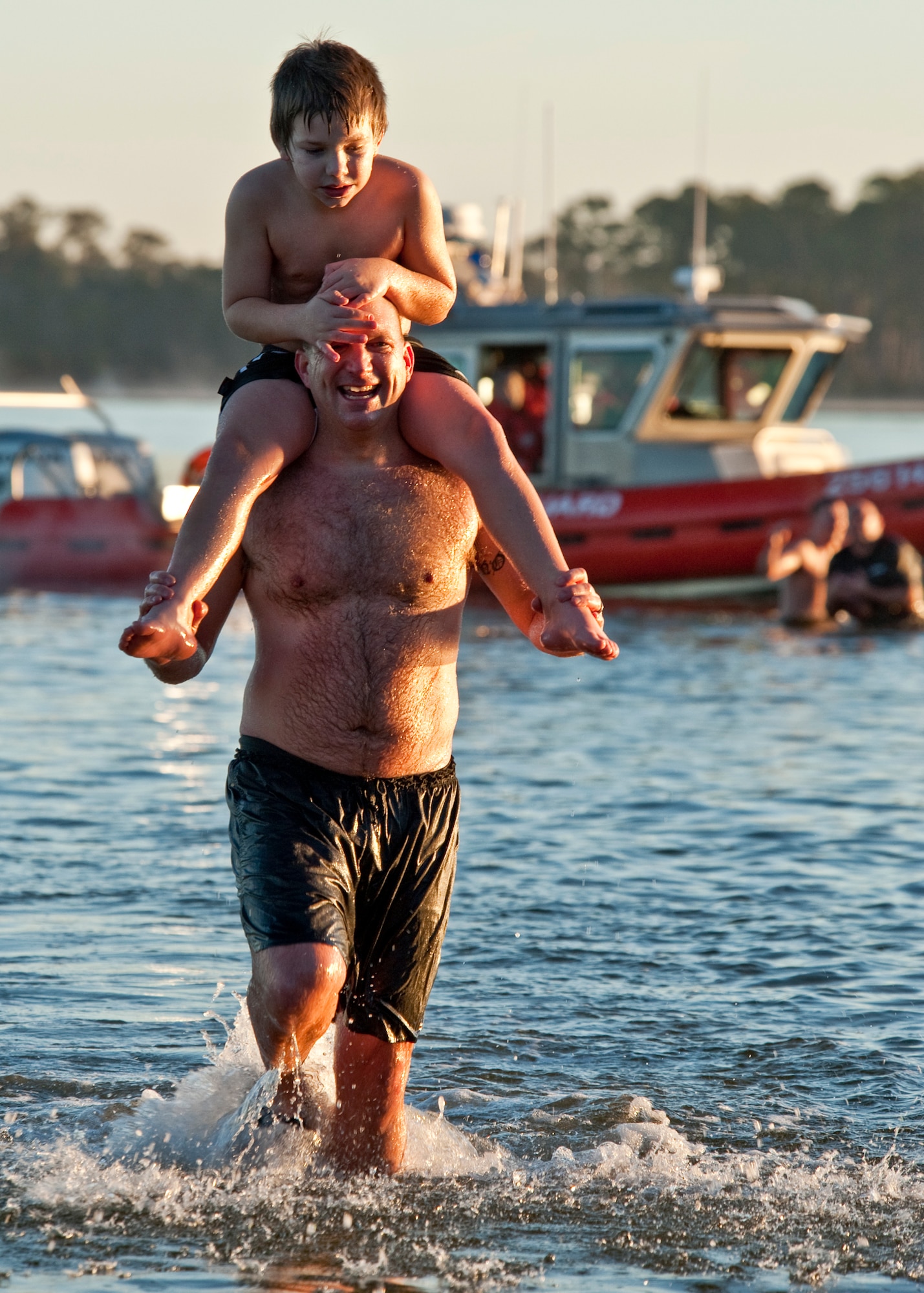 Master Sgt. Christopher Calhoun, 33rd Maintenance Operation Squadron, carries out son William after they shared a ‘very’ quick dunk under the water at Eglin’s first-ever Polar Bear swim, held at Post’l Point, Jan. 7.  More than 100 Team Eglin members braved the 34 degree temperatures and waded into Choctawhatchee Bay, including the 96th Air Base Wing commander and command chief.  (U.S. Air Force photo/Samuel King Jr.)