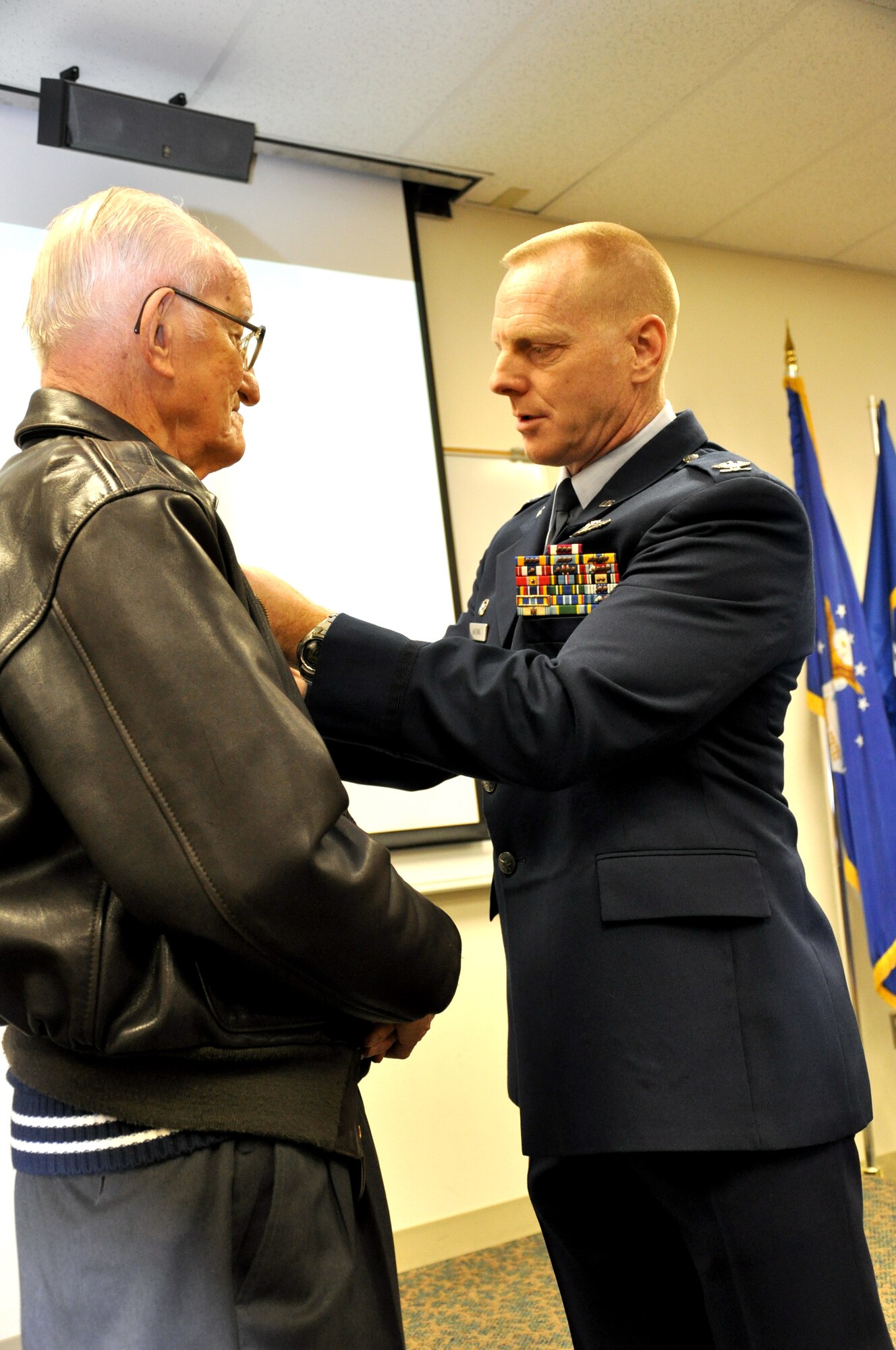 Col. Fred Hartwig, commander of the New Mexico Air National Guard’s 150th Fighter Wing, pins the Distinguished Flying Cross on Army Air Corps veteran 2nd Lt. Robert L. Giles in a Dec. 29 ceremony at Kirtland Air Force Base. During World War II, Lieutenant Giles, a B-17 navigator, saved the life of a severely wounded crewmate. Photo by Army Staff Sgt. Suzanna Dominguez