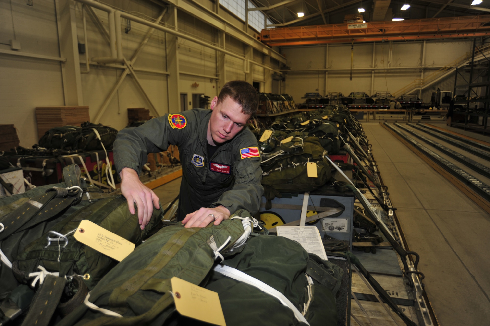 Staff Sgt. Jesse Kessler, 62nd Operations Support Squadron joint air drop inspector, reviews parachutes attached to airdrop cargo Jan. 5 at McChord Field, Joint Base Lewis-McChord, Wash. The tactics shop inspects cargo before and after loading, properly rigs parachutes to cargo and secures all material onto platforms. (U.S. Air Force photo/Airman Leah Young)