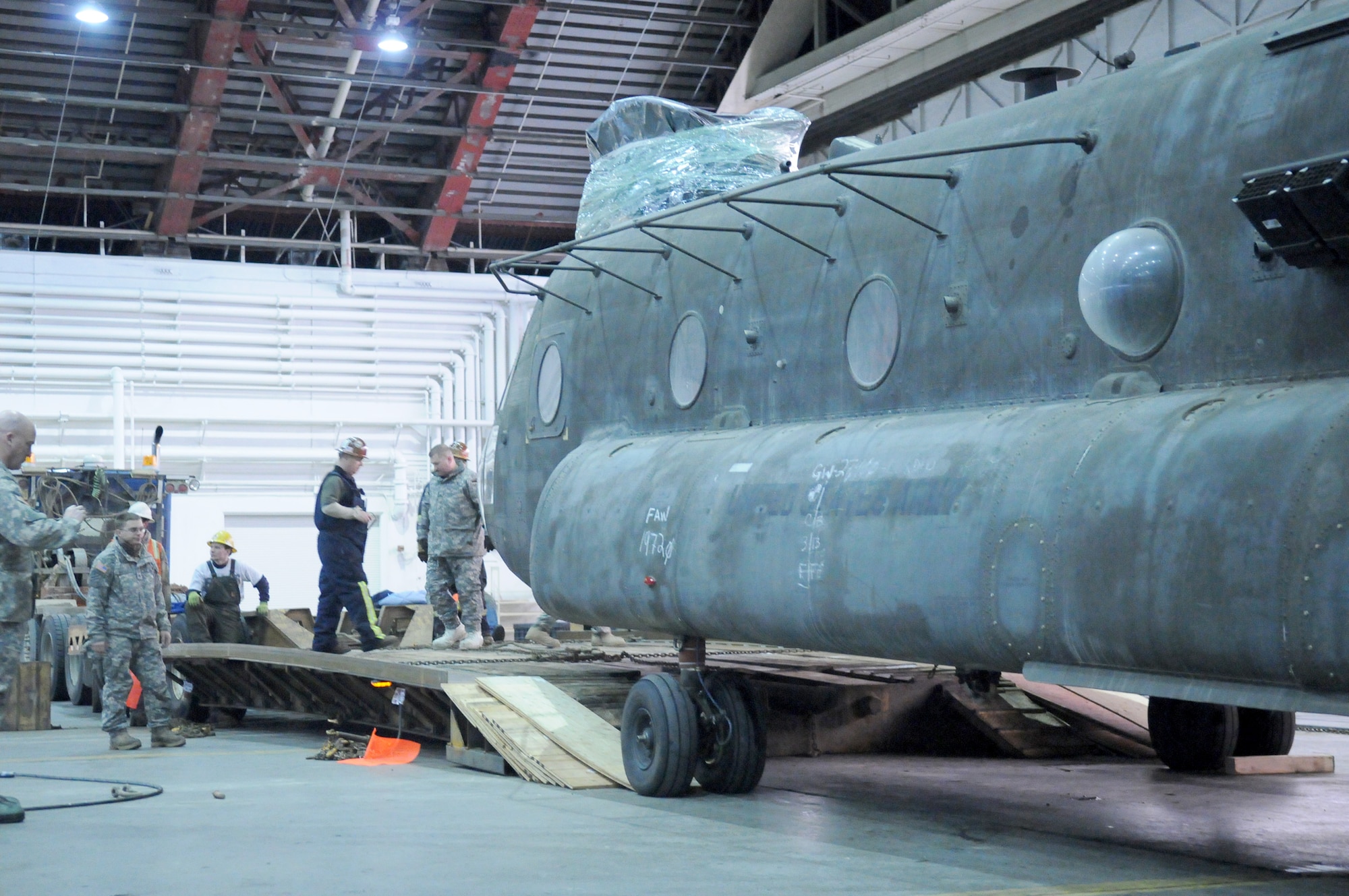 Soldiers load a CH-47 Chinook onto a specially built trailer Dec. 15, 2010, at Eielson Air Force Base, Alaska. After its delivery by C-17 Globemaster III, Soldiers were assisted by Airmen to move the CH-47 to Fort Wainwright, Alaska. The Soldiers are assigned to the 16th Combat Aviation Brigade. (U.S. Air Force photo/Airman 1st Class Janine Thibault)