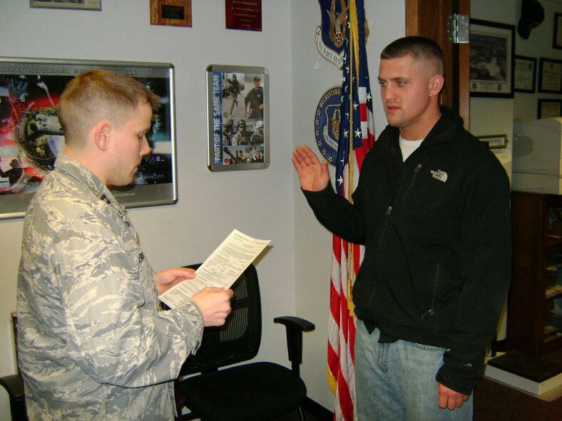 Capt. Ken Enser, 914th Airlift Wing Mission Support Flight commander reads the oath of enlistment to Kurt Mommertz at the Niagara Falls Air Reserve Station January 6 2011.