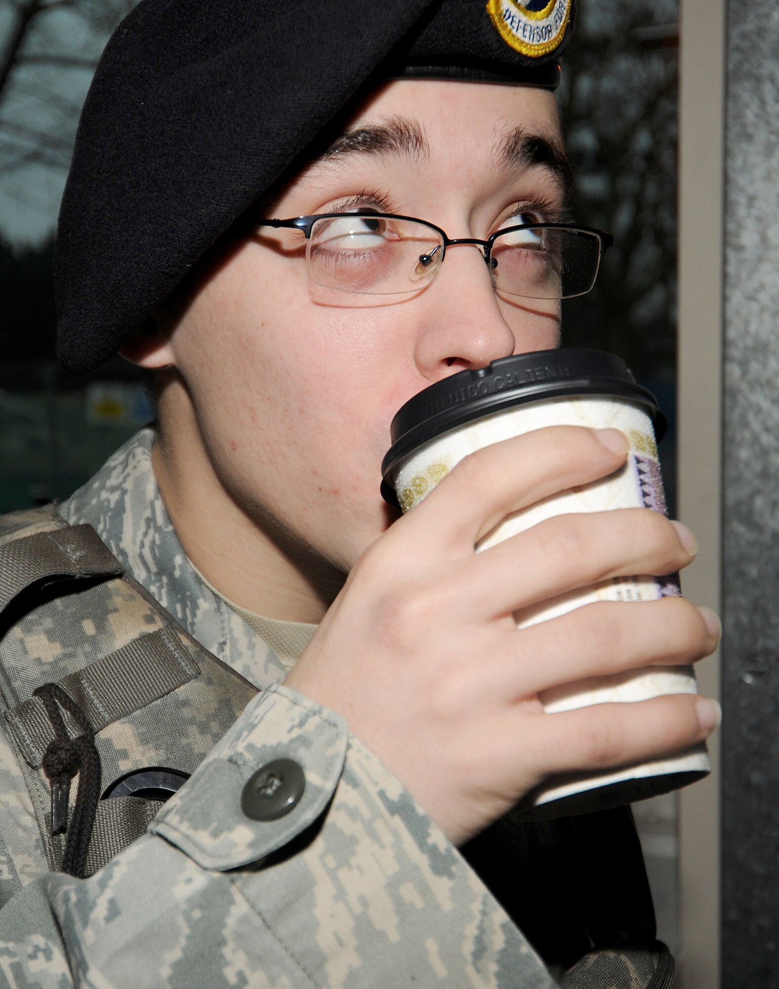 RAF MILDENHALL, England -- Airman 1st Class Collin Magers, 100th Security Forces Squadron entry controller, sips hot chocolate here Jan. 7, 2011.  Airmen from across RAF Mildenhall volunteered to prepare and distribute hot chocolate to the 100th Security Forces Squadron "Defenders" working at gates in the rain.  (U.S. Air Force photo/Senior Airman Tabitha M. Lee)