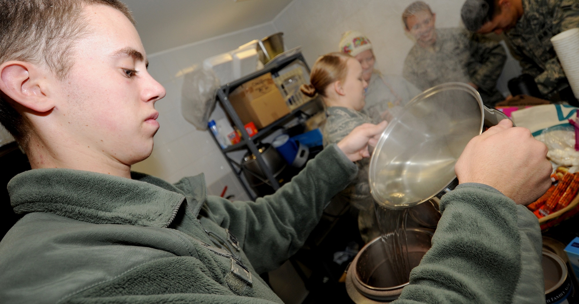 RAF MILDENHALL, England -- Airman 1st Class Kent Casting, 100th Communication Squadron client systems technician, pours water into a thermos while preparing hot chocolate here Jan. 7, 2011.  Participants met at The Loft, a chapel sponsored day room, made hot chocolate and goodie bags, and passed them out to all 100th Security Forces Squadron personnel working the gates.  (U.S. Air Force photo/Senior Airman Tabitha M. Lee)  