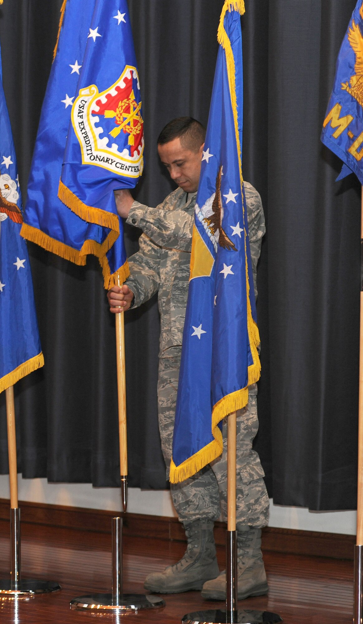Chief Master Sgt. Jeffrey Cui replaces the 18th Air Force flag with the U.S. Air Force Expeditionary Center flag during a re-alignment ceremony Jan. 6, 2011, at Joint Base McGuire-Dix-Lakehurst, N.J. The expeditionary center assumed command of five former 18th Air Force units as part of re-structuring within Air Mobility Command. Chief Cui is the U.S. Air Force Expeditionary Center command chief master sergeant. (U.S. Air Force photo/Tech. Sgt. Zachary Wilson) 