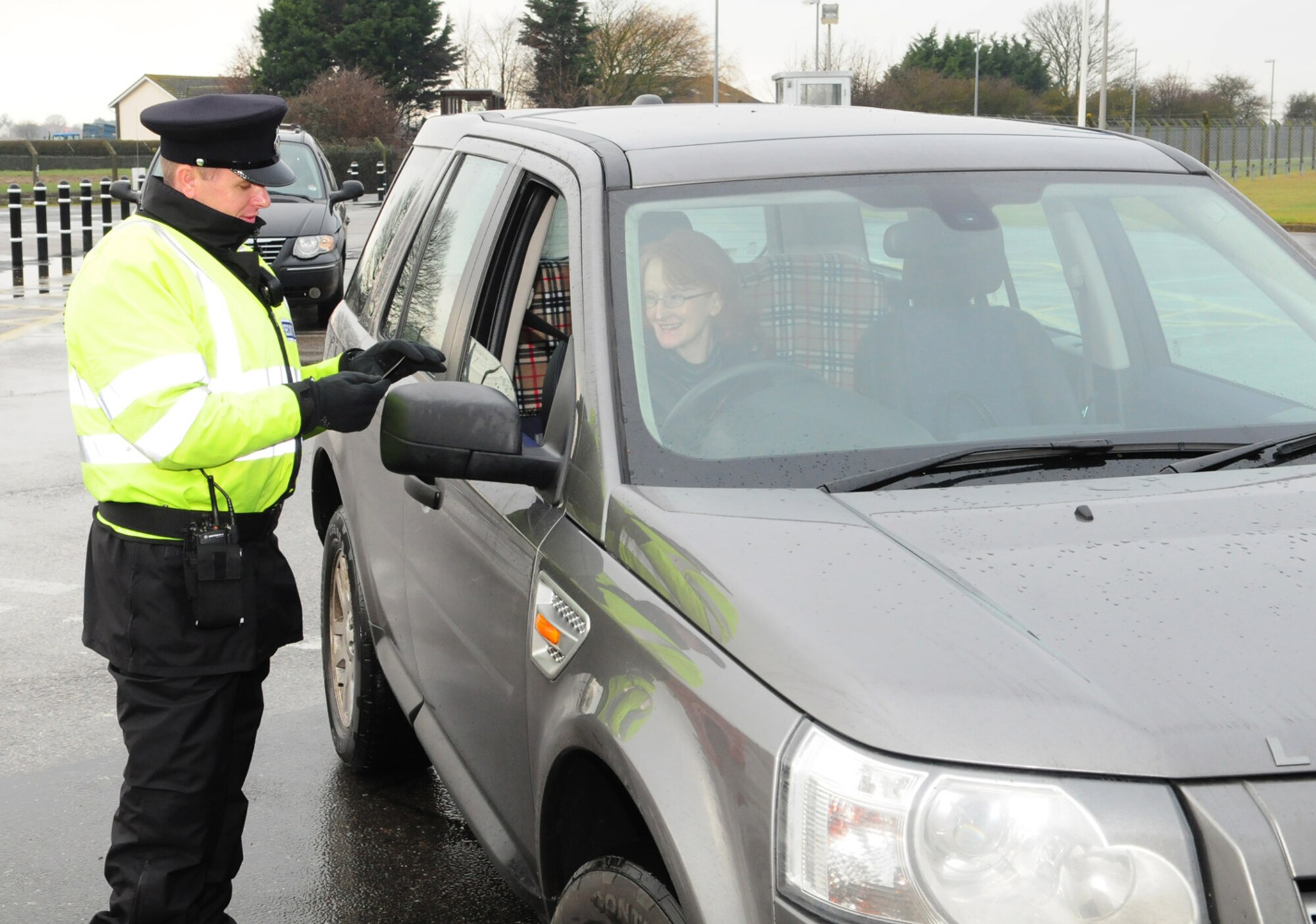 RAF MILDENHALL, England -- Civilian Security Officer 5 Roger Beeby, Ministry of Defence Security, checks IDs at the West Row Gate here Jan. 7, 2011.  As part of the 2010 Quality of Life survey, the operating hours at the West Row Gate have been extended. (U.S. Air Force photo/Karen Abeyasekere)