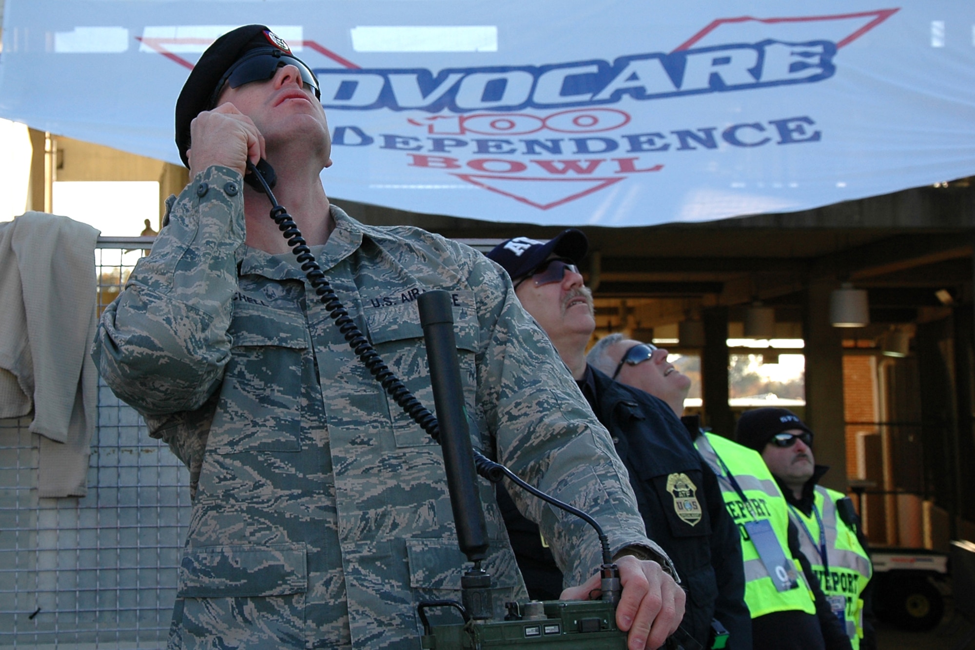 Senior Airman Sean Mitchell, joint terminal attack controller, Det 1 20th Air Support Operations Squadron, watches as Air Force parachutists jump from their plane just before the kickoff of the Advocare V 100 Independence Bowl in Shreveport, La., Dec. 27, 2010. The U.S. Air Force Academy Falcons faced off against the Georgia Tech Yellow Jackets in the contest and came out with the win 14-7. (U.S. Air Force photo/ Senior Airman Kimberly Simon)   