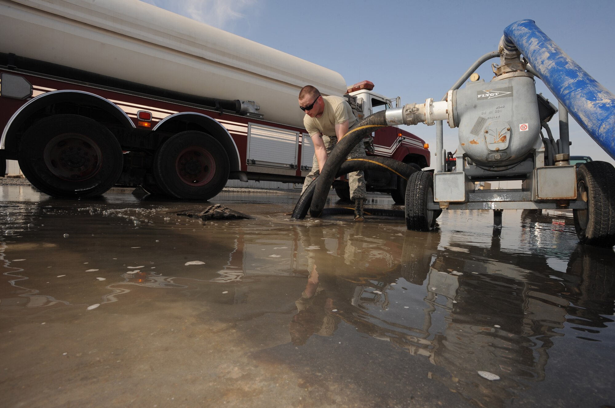 Airman 1st Class Leonard Stroud, 380th Expeditionary Civil Engineer Squadron, ensures the water drain is working properly Jan. 5, 2011, during a Flood Response Exercise at an undisclosed location in Southwest Asia. The FRE is used as a training tool to ensure Airmen are prepared to immediately moderate water overflow. (U.S. Air Force photo by Senior Airman Maynelinne De La Cruz)(Released)
