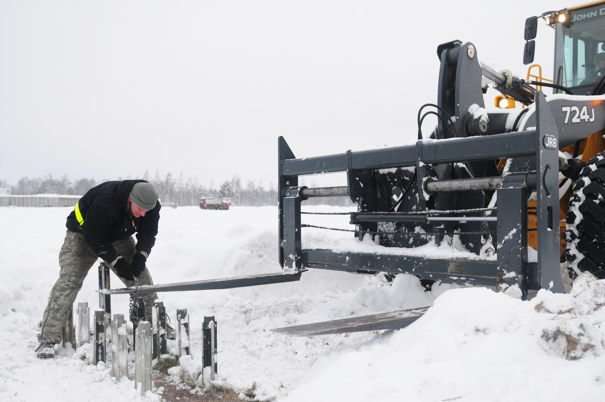 LITHUANIA AIR FORCE AIR BASE, Lithuania – Staff Sgt. Brian Splaine, 493rd Expeditionary Fighter Squadron barrier maintenance craftsman, wraps a chain around a post used to anchor a mobile aircraft arresting unit for removal on Jan. 5. Sergeant Splaine is deployed to the 493rd EFS at Lithuania Air Force Air Base, Lithuania from the 435th Construction and Training Squadron at Ramstein Air Base, Germany, in support of the NATO Baltic air policing mission. (U.S. Air Force photo/Staff Sgt. Stephen Linch)