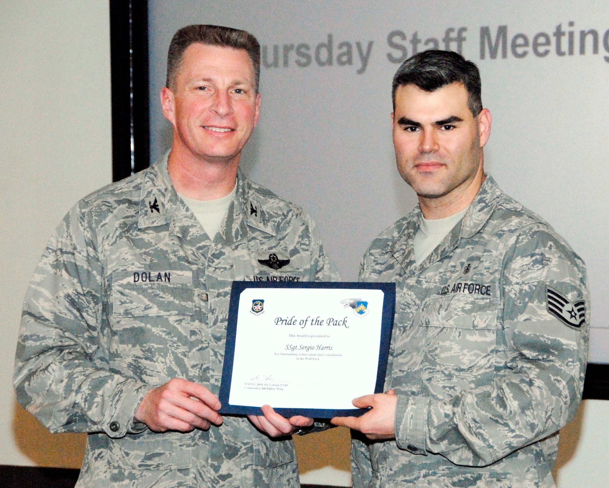 KUNSAN AIR BASE, Republic of Korea -- Col. John Dolan, 8th Fighter Wing commander, presents Staff Sgt. Sergio Harris, 8th Medical Support Squadron, with a Pride of the Pack award Jan. 6. (U.S. Air Force photo/Capt. Sheryll Klinkel) 