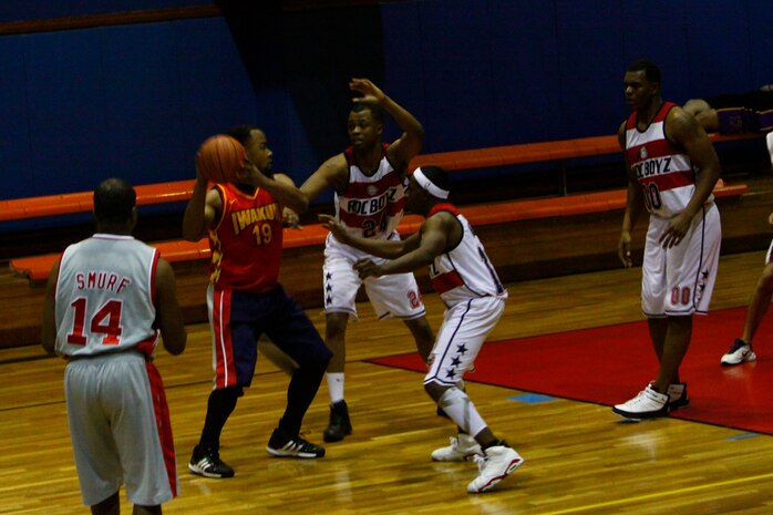 Courtney Simmons, Sho Stoppaz center, works the Roc Boyz defense as teammate Rabosky Tanner, point guard, sets up for a 3-point shot to help widen the lead during the second half of the championship game of the Make The Dream Real basketball tournament at the IronWorks Gym sports courts here Saturday. The Sho Stoppaz dominated during the entire tournament and defeated the Roc Boyz 50-40 in the championship game.