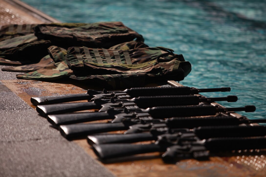 On day two of the Modular Amphibious Egress Trainer course, Marines don part of their combat load including a life preserver unit, flak and a rifle as part of a training exercise here Jan. 7. The course teaches Marines and sailors how to escape from a submerged helicopter utilizing an Intermediate Passenger Helicopter Aircrew Breathing Device, which is similar to a small scuba tank that provides up to two minutes of compressed air.