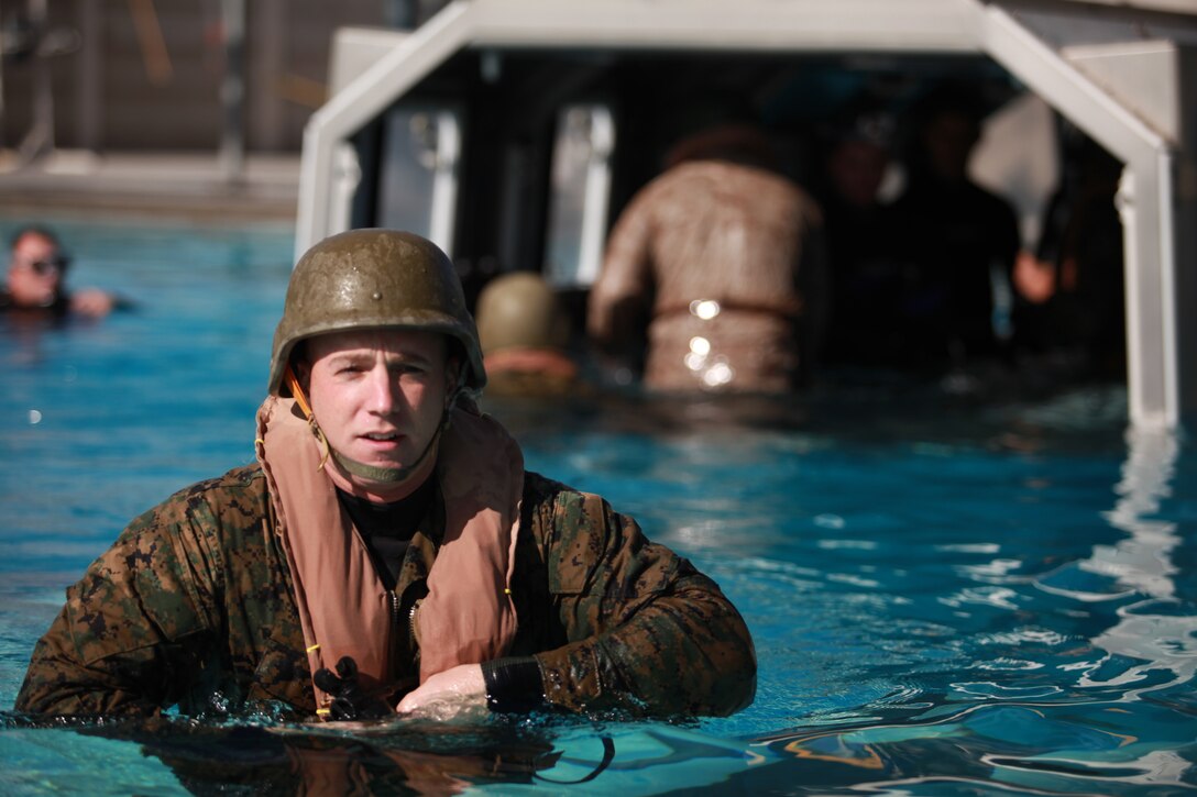 Staff Sgt. Paul D. Daly, the 11th Marine Expeditionary Unit antiterrorism force protection chief, emerges from a Modular Amphibious Egress Trainer exercise here Jan. 7. As the helo dunker is submerged underwater, a group of six Marines inside made their way out of the helicopter trainer through one of the emergency exits located in the simulated aircraft. The two-day course provides military personnel with the skills necessary to coordinate an egress from a ditched helicopter and survive at sea until rescue.