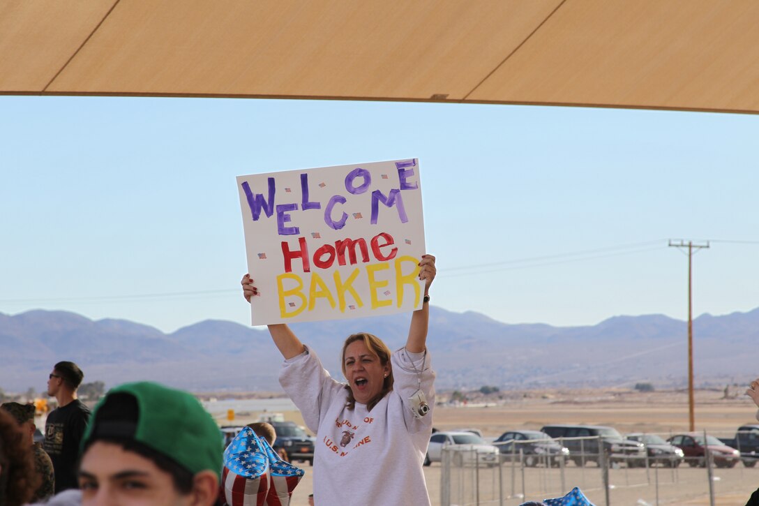 Marine mom Maria Gonzales-Plimpton holds a sign up welcoming home the Marines of Baker Company at the Del Valle soccer field Jan. 6, 2011.  Maria’s son, Lance Cpl. George Plimpton, a team leader with Battalion Landing Team 1st Battalion, 7th Regiment, has been on a eight-month-long deployment.