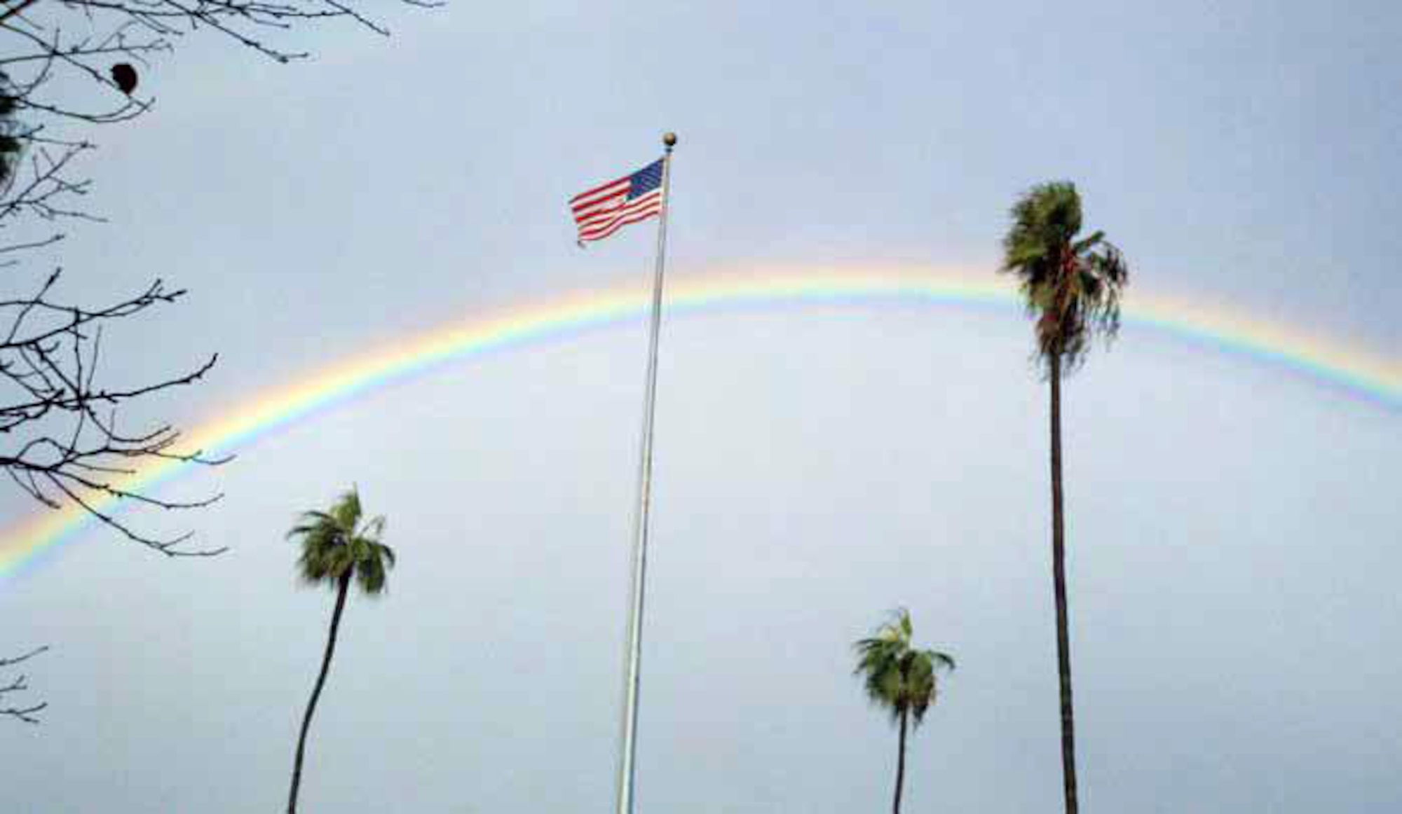 A rainbow arcs over the flagpole and palm trees in front of the wing headquarters building. Senior base meteorologist Mark Ditter said December was a record breaking month. “That was our rainiest December on record on the base, ever,” he said. Previously, the record had been 6.1 inches. December 2010 saw 7.6 inches of rain. (U.S. Air Force photo by Valerie Palacios)
