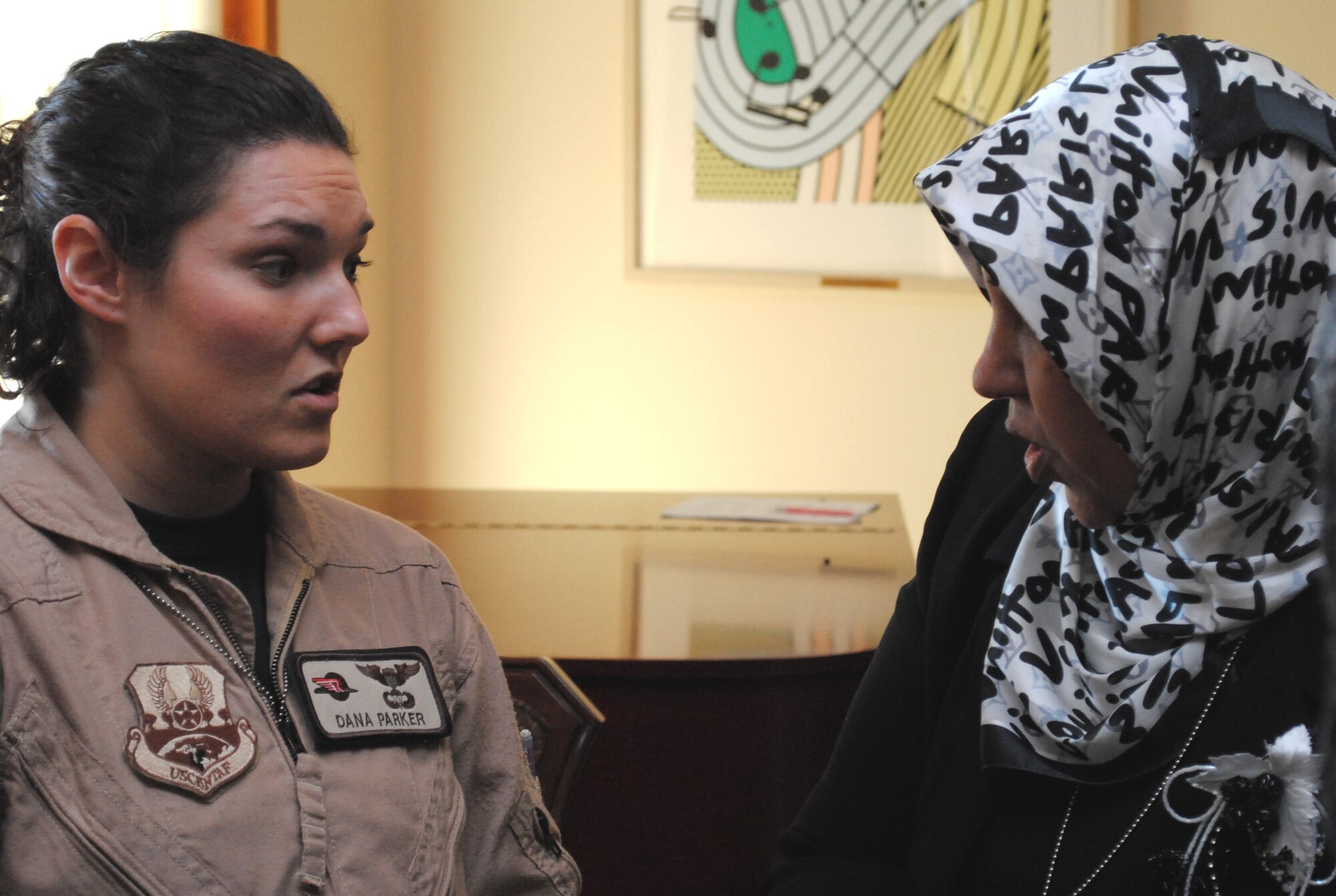 U.S. Air Force Capt. Dana Parker, 362nd Expeditionary Reconnaissance Squadron C-130 and MC12 pilot, and Marysville, Wash., native, talks to Makarim Al-Yassiri, Najaf Airport flight attendant, about her experiences in aviation, Jan. 7, during a luncheon at the U.S. Embassy for the Horizon East Women in Aviation, International chapter here in Iraq. The Women in Aviation, International was established to encourage women to seek opportunities in aviation career fields and interests. (U.S. Army photo by SPC Amie J. McMillan)