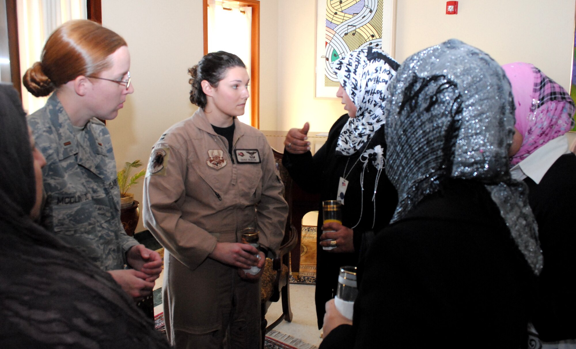 U.S. Air Force Capt. Dana Parker, 362nd Expeditionary Reconnaissance Squadron C-130 and MC12 pilot, and Marysville, Wash., native, and 2nd Lt. Lila McClintoc, 332nd Expeditionary Aircraft Maintenance Squadron maintenance officer and Birmingham, Ala., native, speak to several Iraqi women about their experiences in aviation, Jan. 7, during a luncheon at the U.S. Embassy for the Horizon East Women in Aviation, International chapter here in Iraq. The Women in Aviation, International was established to encourage women to seek opportunities in aviation career fields and interests. (U.S. Army photo by SPC Amie J. McMillan)