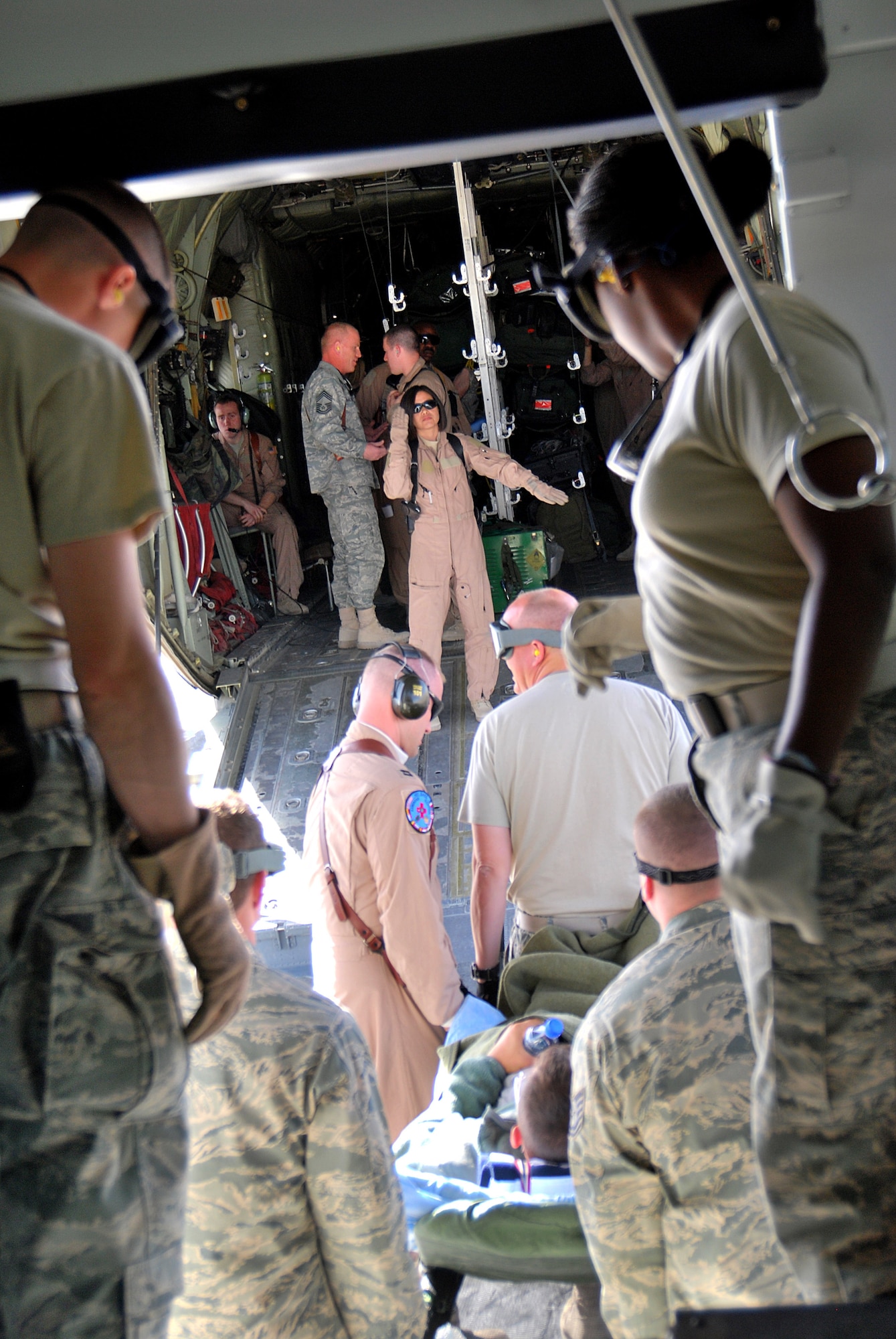 Members of the 451st Expeditionary Aeromedical Evacuation Squadron work together to load patients onto a C-130H Hercules Jan. 5, 2011, at Kandahar Airfield, Afghanistan, for an aeromedical evacuation. The critical care air transport team is a specialized three-person team that recreates an intensive care unit environment within an aircraft during aeromedical evacuations. (U.S. Air Force photo by Senior Airman Melissa B. White/Released)