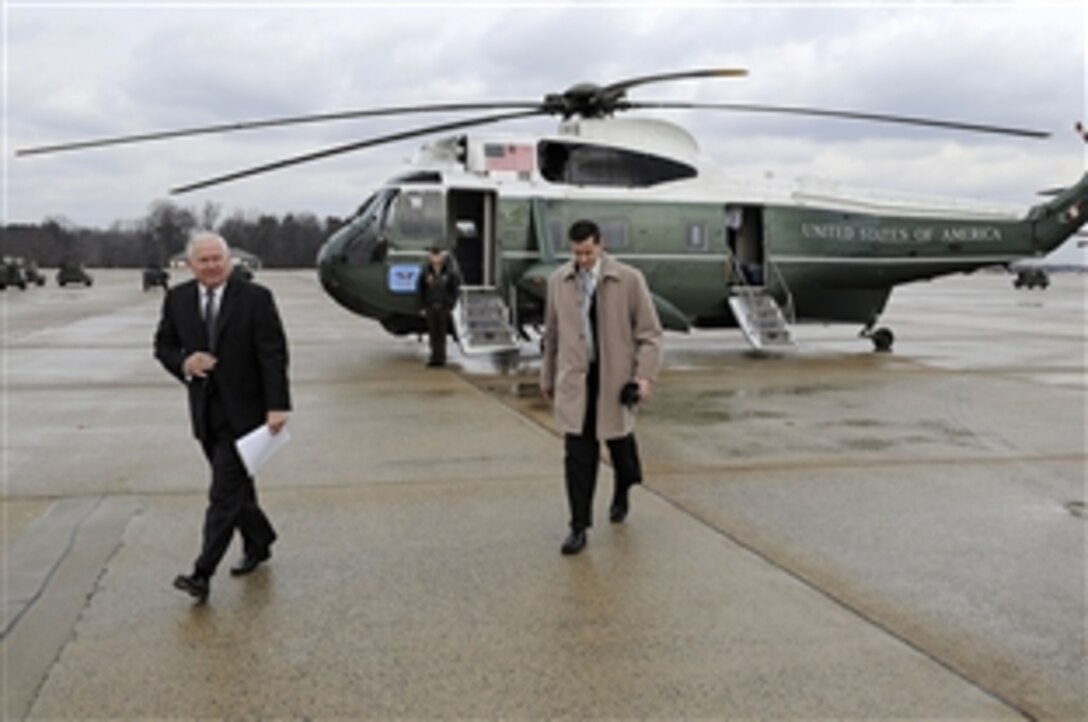 U.S. Defense Secretary Robert M. Gates and a member of his staff walk away from a Marine One helicopter as they prepare to board the National Airborne Operations Center aircraft on Andrews Air Force Base, Md., Jan. 8, 2011. Gates departed on a seven-day trip to China, Japan and South Korea to discuss defense issues. 