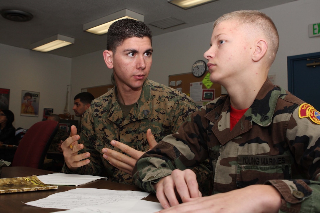 Sgt. Louis Abrams, an instructor with the Miramar Young Marines Program, tutors a Young Marine during a lesson plan over interior guard procedures at the Motorcycle Safety Course building here Jan. 9. After the lesson, Young Marines were given a class on the importance of education and a drug-free lifestyle.