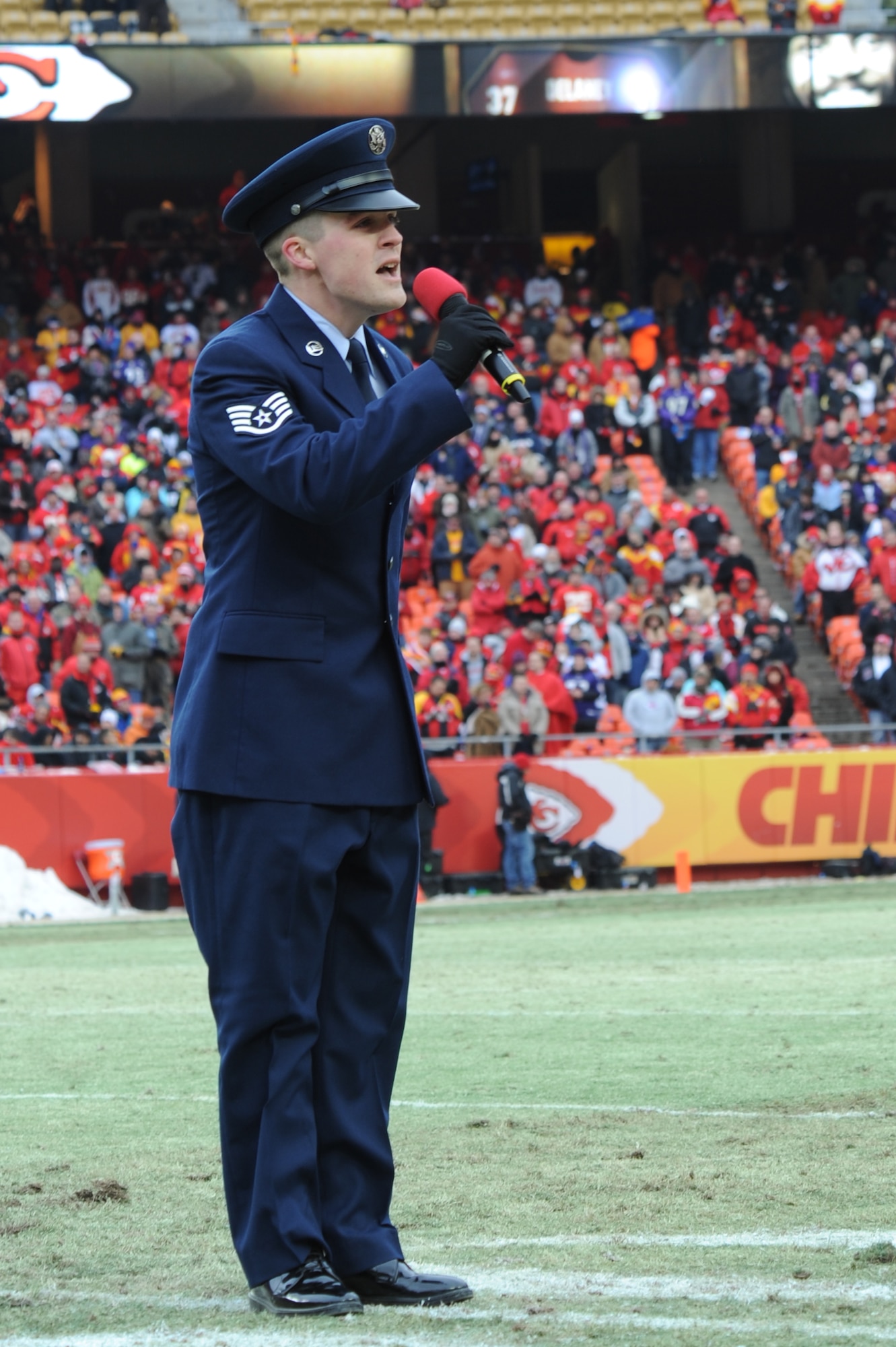 KANSAS CITY, Mo. - Staff Sgt. Nathan Tawbush, 19th Munitions Squadron weapons maintenance team chief, sings 'God Bless America' during the half-time show of the Kansas City Chiefs' Wild Card game against the Ravens Jan 9. The Ravens beat the Chiefs 30-7, advancing to the next round. (U.S. Air Force photo by Senior Airman Carlin Leslie)

