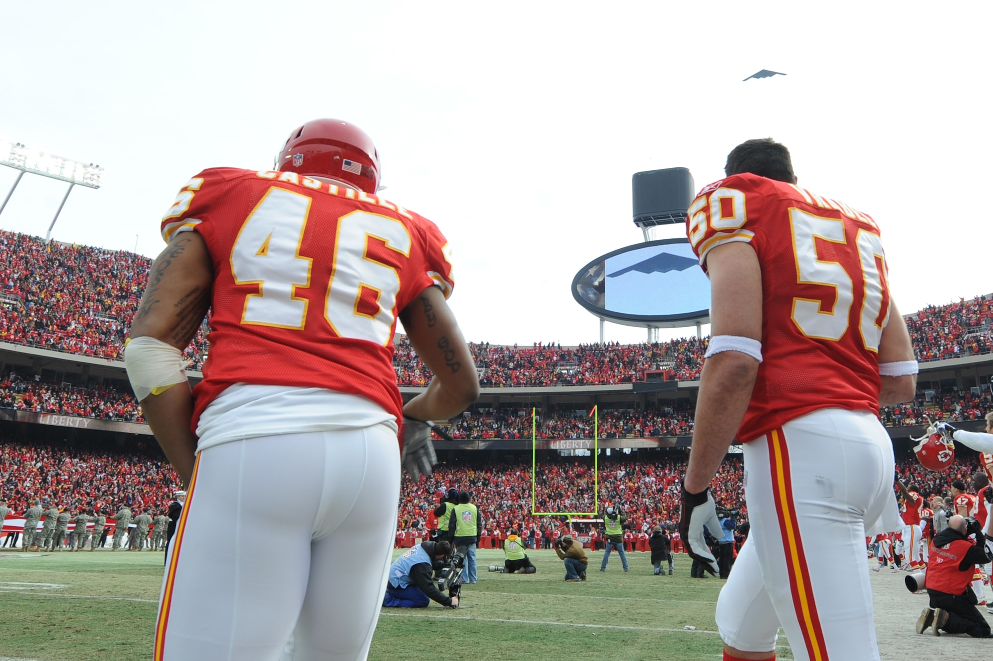 KANSAS CITY, Mo. - Tim Castille, a running back, and Mike Vrable, a linebacker for the Kansas City Chiefs, watch as a B-2 stealth bomber from the 509th Bomb Wing flies overhead during the opening ceremonies of the Kansas City Chief’s Wild Card play-off game Jan 9. (U.S. Air Force photo by Senior Airman Carlin Leslie)