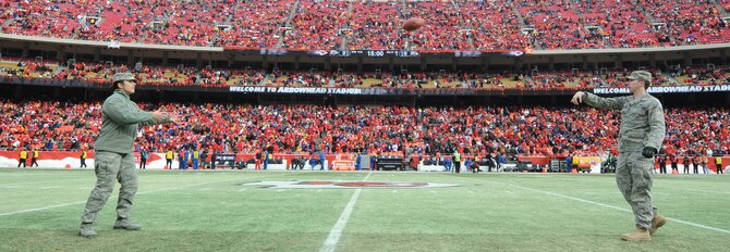 KANSAS CITY, Mo. - Senior Airman Lindsey Jaxel and Senior Airman Shaun Hampton, 509th Force Support Squadron military personnel flight, throw the first pass of the Kansas City Chief’s Wild Card play-off game against the Baltimore Ravens Jan 9. (U.S. Air Force photo by Senior Airman Carlin Leslie)