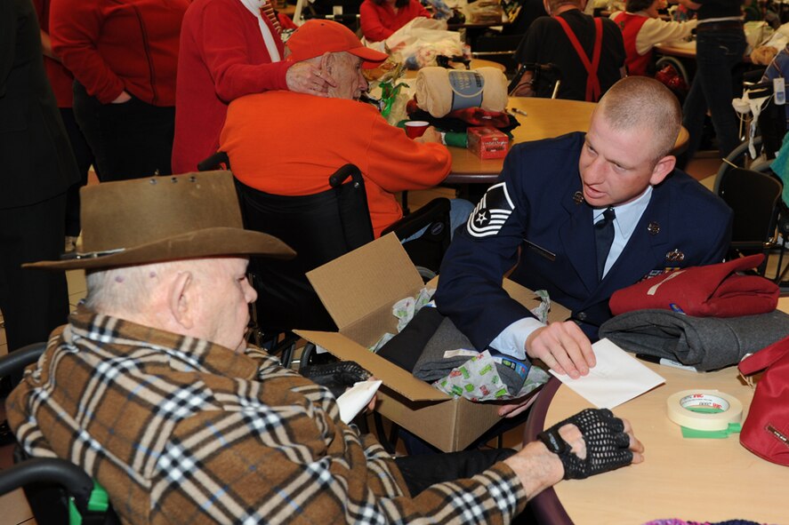 Master Sgt. Lehi Hartwell, 124th Maintenance Squadron, helps a resident of the Boise Veterans Home open his gifts Dec. 23.
