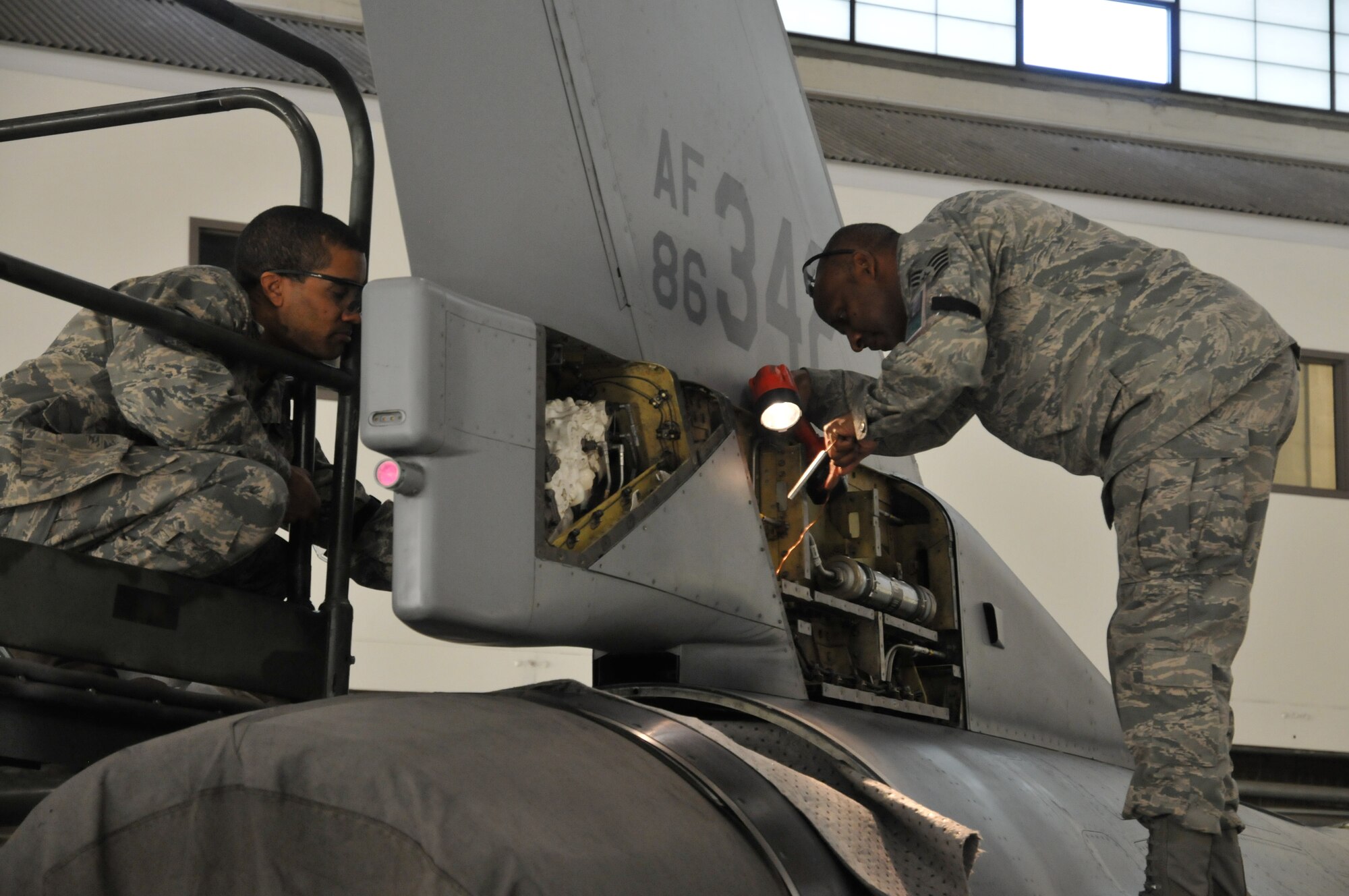 Staff. Sgt. Ebon Mitchell (left) and Staff Sgt. Michael Chapman (right) ,113th Wing Maintenance Group, District of Columbia Air National Guard, replace F-16 body panels after a 300-hour phase inspection Jan. 7, 2011 at Joint Base Andrews, Md. (U.S. Air Force photo by Tech. Sgt William R. Parks)