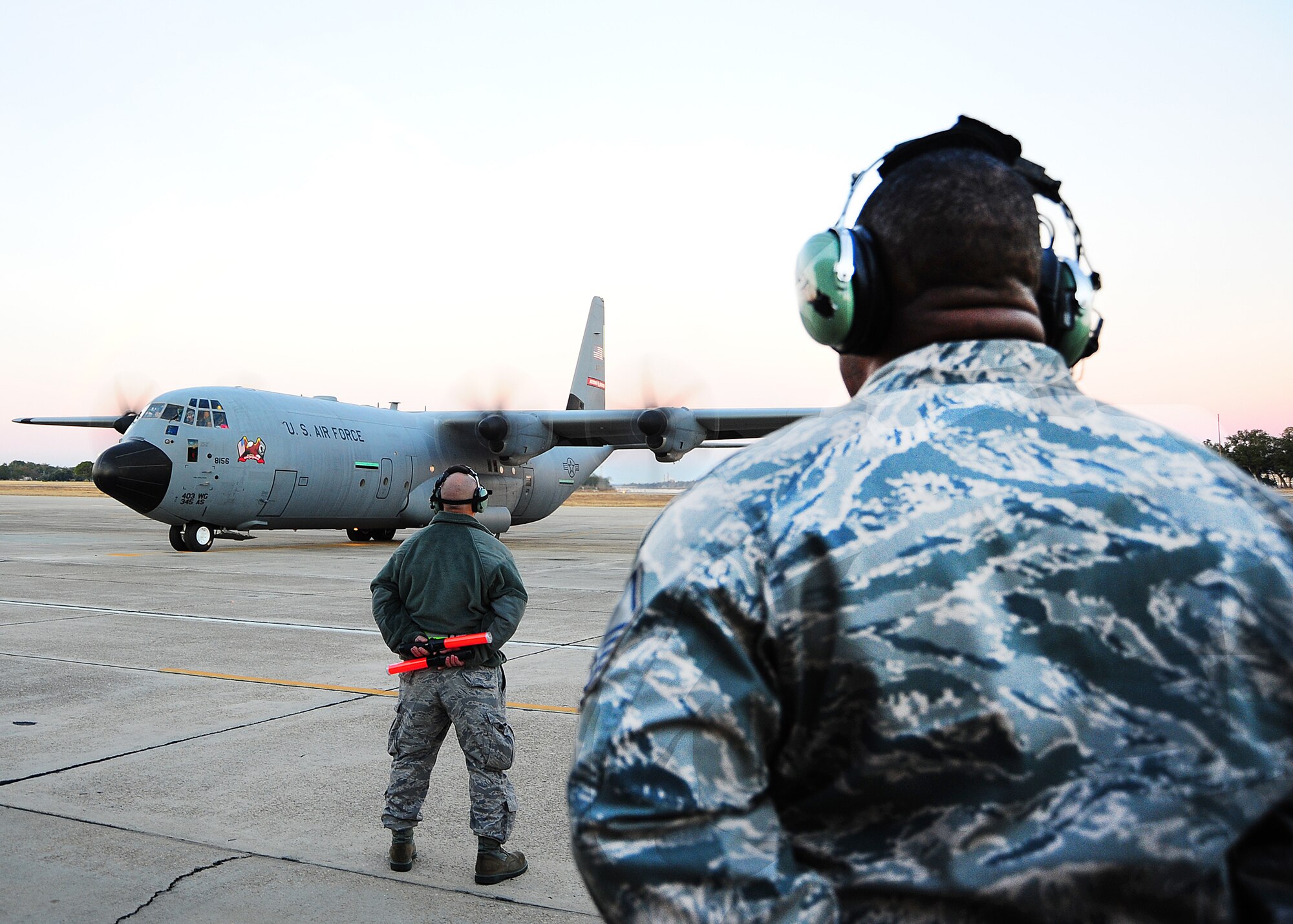 In the final moments before departure, members of the 403rd Wing stand by, waiting to render a final salute to deployers.  Reservists with the 403rd Maintenance Group and 815th AS and active-duty members from the 345th AS deployed for 120 days in support of overseas contingency operations in Southwest Asia. The 815th "Flying Jennies" and 345th "Golden Eagles," an active associate unit, work and train side-by-side as part of the 403rd Wing at Keesler Air Force Base, Miss.  (U.S. Air Force photo by Staff Sgt. Yolanda Addison)

