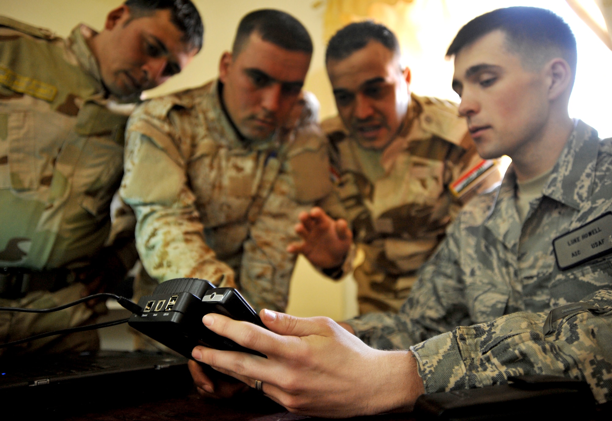 Airmen 1st Class Luke Howell, Camp Liberty Document and Media Exploitation analyst, shows Iraqi soldiers how to use a CelleBrite machine to rip a phone Jan. 5 on Joint Security Station Constitution, Iraq. The DOMEX mission is to gather actionable intelligence from documents, electronic devices and other materials collected on the battlefield. (U.S. Air Force photo by Senior Airman Andrew Lee)