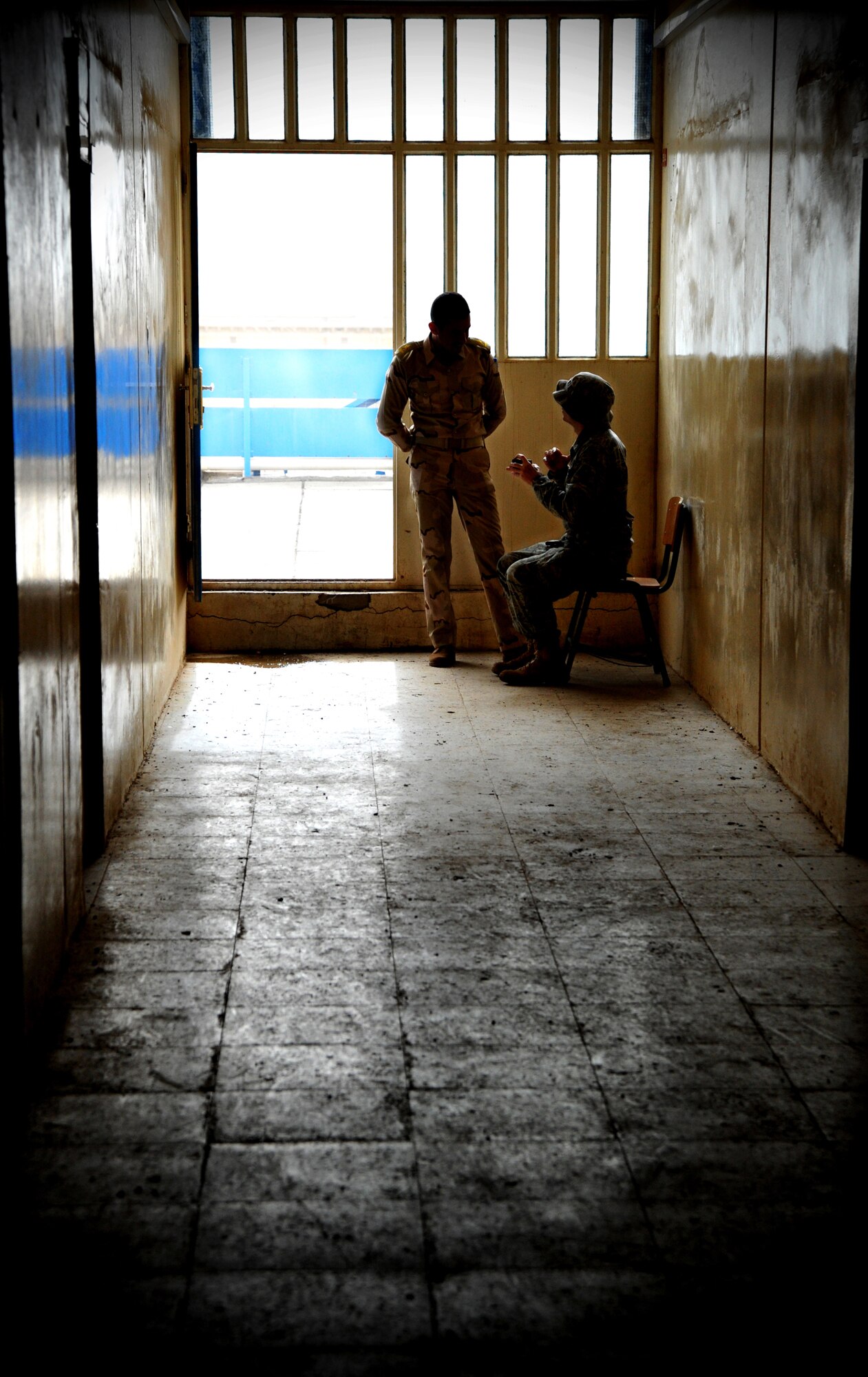 Lt. Col. Christopher Finta, 821st Expeditionary Training Squadron director of operations, talks with an Iraqi airman in the hallway of the Iraqi Air Force Training School Dec. 13, 2010, in Taji, Iraq. The 821st ETRS works daily with the faculty and students at the school to help it become an enduring and self-sufficient training pipeline for the Iraqi Air Force and Ministry of Defense. (U.S. Air Force photo by Senior Airman Andrew Lee)