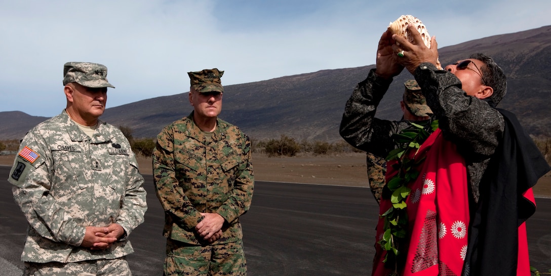 (From left to right) Army Maj. Gen. Joseph Chaves, deputy commanding general for the Army National Guard, U.S. Army, Pacific, and Brig. Gen. John J. Broadmeadow, U.S. Marine Corps Forces, Pacific’s deputy commander, observe Daniel Akaka, a Kahu (keeper of Hawaiian culture,) as he performs a Hawaiian purification ceremony known as the Pikai Jan. 10 at the Pohakuloa Training Area during the Cooper Airfield ribbon cutting ceremony. ::r::::n::The new airfield, intended for training exercises utilizing unmanned aerial vehicles, is the first of many MarForPac and USARPAC collaborations aimed at improving the training facility.