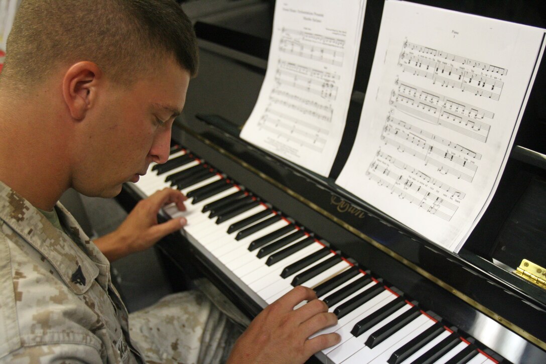 Corporal Lee J. Glasser, a tuba player for the 2nd Marine Division Band, demonstrates his musical diversity by playing a song with the piano aboard Marine Corps Base Camp Lejeune, N.C. Many of the band members can play multiple instruments.