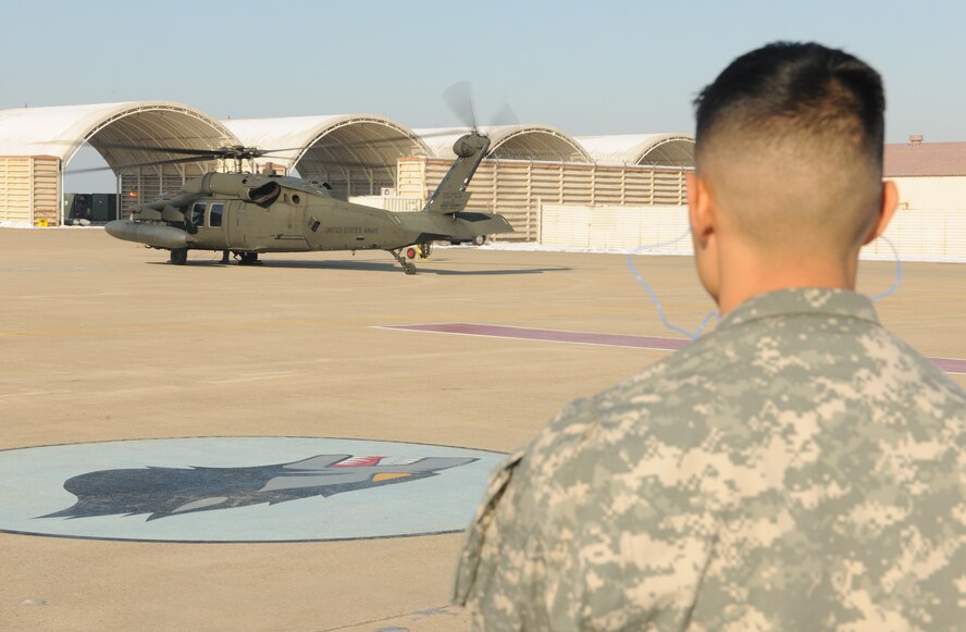 KUNSAN AIR BASE, Republic of Korea -- Army Capt. Lee Jin, 8th Fighter Wing ground liaison officer, watches a UH-60 Black Hawk from Camp Humphreys, Republic of Korea, taxi here Jan. 7. Captain Jin invited a team from the 2-2 Aviation Regiment, 2nd Combat Aviation Brigade, here to educate Wolf Pack pilots and 8th Operations Group intelligence Airmen on Army aviation assets. (U.S. Air Force/Senior Airman Ciara Wymbs)