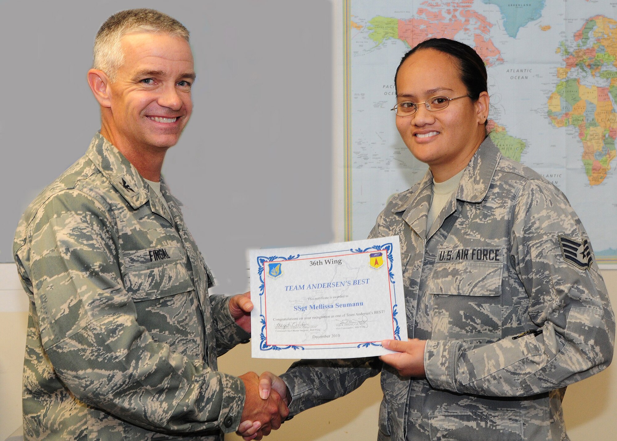 Col. Tod Fingal, 36 Wing vice commander, presents Staff Sgt. Mellissa Seumanu, 36 Logistics Readiness Squadron, with the  Andersen's Best award here Dec. 16. As 36th Logistics Readiness Squadron deployment manager, Sergeant Seumanu ensures the 36th Wing quickly fills all Air Expeditionary Force taskings providing Pacific Air Power from Andersen Air Force Base. Andersen's Best is a recognition program which highlights a top performer from the 36th Wing. (Photo illustration/Senior Airman Nichelle Anderson)