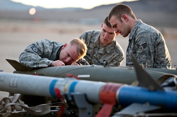 NELLIS AIR FORCE BASE, Nev. --  Staff Sgt. Shane Tescher, Airman 1st Class James Freeman and Senior Airmen Adam Badgley, 757th Aircraft Maintenance Squadron aircraft armament systems weapons load team,  prepare a MK-82 bomb to be loaded on an A-10 Thunderbolt II during a weapons load competition on the Nellis flightline Jan. 7.  Weapons load competitions are conducted quarterly to keep Airmen sharp and recognize superior performers. Weapons load teams are evaluated for use of the checklist, safety, and overall speed. (U.S. Air Force photo by Airman 1st Class George Goslin)
