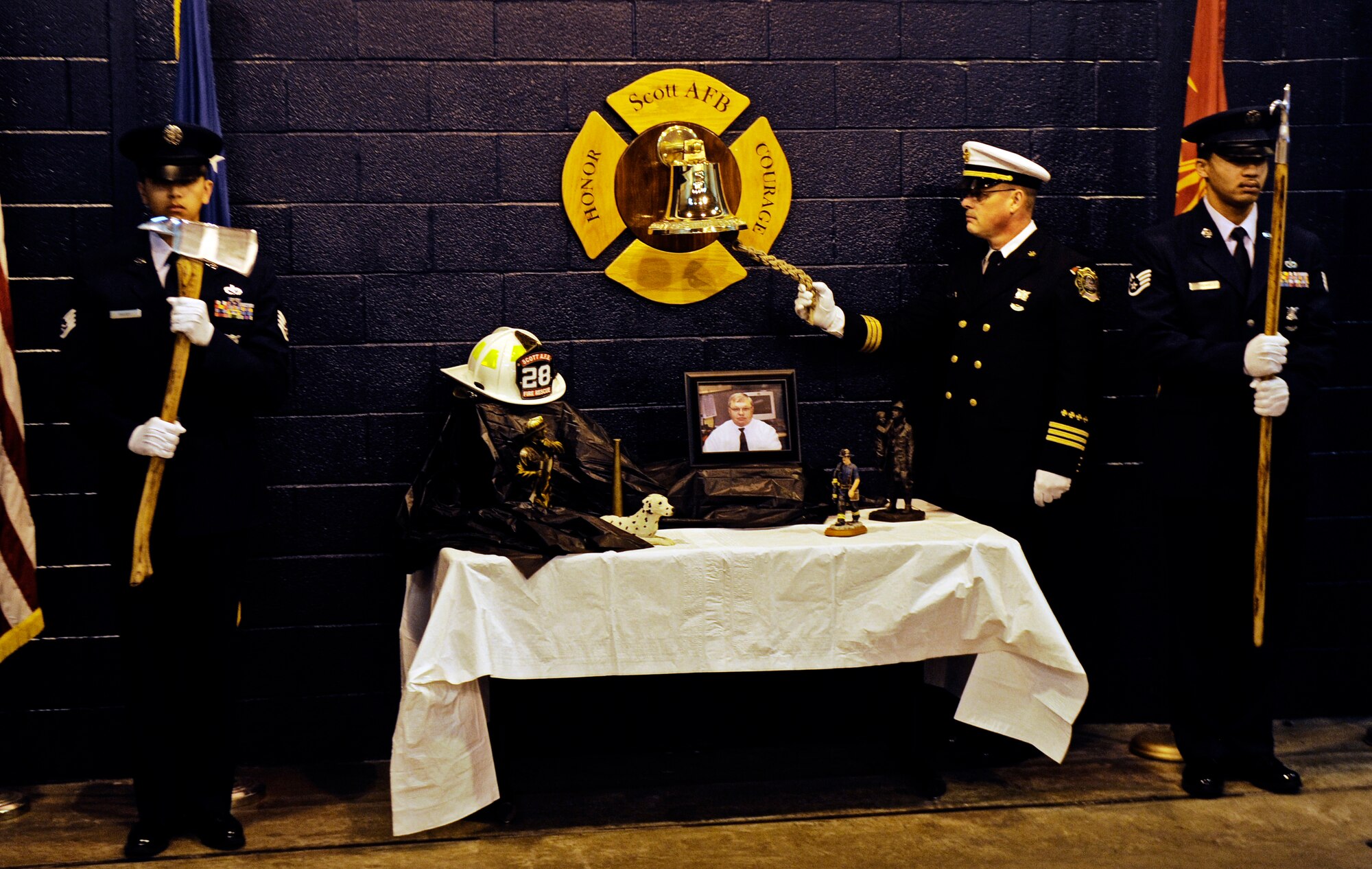 A flight of firefighters stands by as a few final words are said about Rick Grammer, Air Mobility Command fire chief, during a Final Alarm Ceremony Jan. 10, 2010 at Scott Air Force Base, Ill. Mr. Grammer passed away last week.  A Final Alarm Ceremony is a traditional final tribute to a firefighter who has passed.  The ceremony begins by calling the passed firefighter’s name and is followed by the ringing of the ceremonial fire bell.  Bagpipes are also commonly played.  The ceremony represents the firefighter’s final call to duty. (U.S. Air Force photo/ Staff Sgt. Ryan Crane)