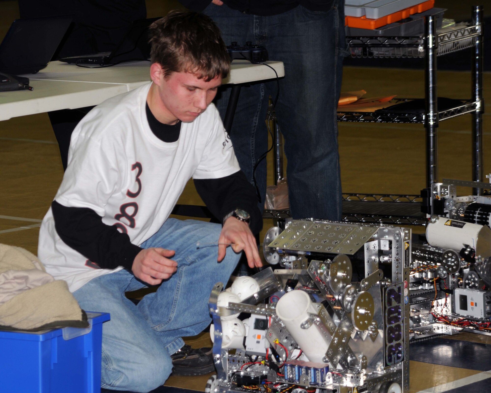 ALTUS AIR FORCE BASE, Okla. -- The Longshots team member, Elisha Moncrief, works on one of the robots used during a robotics demonstration Jan. 6 for the children at the Youth Center here. The demonstration was given by The Longshots, the robotics team from the Southwest Technology Center, to kick off the opening of a new robotics program at the Youth Center. (U.S. Air Force photo by Airman 1st Class Kenneth W. Norman)