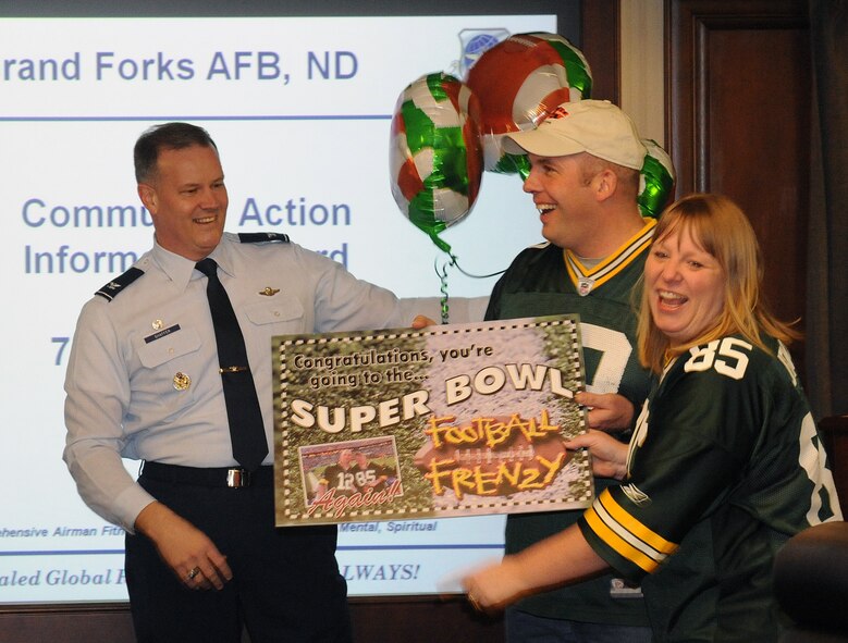 Col. Don Shaffer, 319th Air Refueling Wing commander, presents Super Bowl tickets from the Air Force sponsored Football Frenzy contest Jan. 7 to Master Sgt. Jay Peavey, 319th Security Forces Squadron, and his wife Jennifer on Grand Forks Air Force Base. This is the couple’s second consecutive year winning Super Bowl tickets. (U.S. Air Force photo by Tech Sgt. Johnny Saldivar)