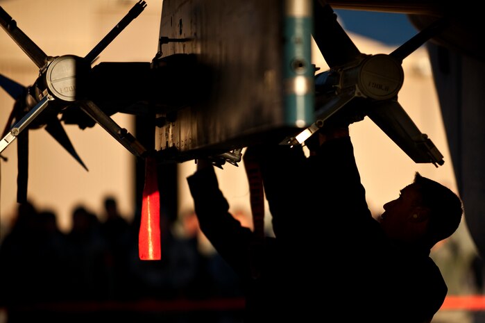 NELLIS AIR FORCE BASE, Nev. --  Staff Sgt. Eric Crawley, Senior Airman Phillip Hohner, and Senior Airmen Jolin Daigneault, 757th Aircraft Maintenance Squadron aircraft armament systems weapons load team, load a AIM-9 air to air missile on a F-15 Eagle during a weapons load competition on the Nellis flightline Jan. 7. Weapons load competitions are conducted quarterly to keep Airmen sharp and recognize superior performers. Weapons load teams are evaluated for use of the checklist, safety, and overall speed. (U.S. Air Force photo by Tech Sgt. Michael R. Holzworth)
