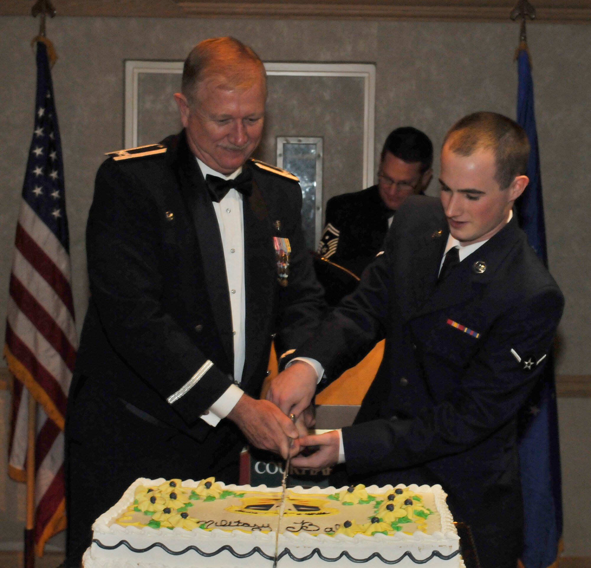 PATRICK AIR FORCE BASE, Fla. - During the Air Force Reserve's 920th Rescue Wing fifth annual military ball, the highest-ranking person and youngest person in attendence, got to cut the cut. Col. Robert Dunn, the 920RQW Commander, held the most rank, and joining him was, Airman Brett Ludwick, the youngest Airman who works at the 920th RQW Command Post. (U.S. Air Force photo/Capt. Ryan Liss)