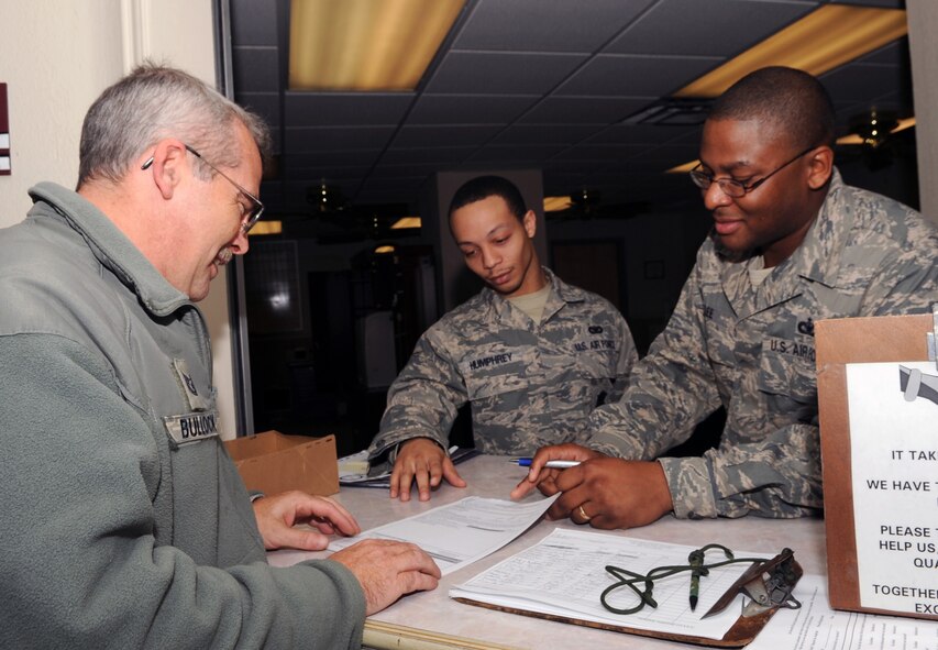 BARKSDALE AIR FORCE BASE, La. -- Tech. Sgt. John Bullock, 2nd Maintenance Squadron, reviews paperwork with Senior Airman Tyvenskione Humphrey and Staff Sgt. Jamey Lee, 2nd Security Forces Squadron, before getting his security badge photo taken. Nearly five percent of previously issued badges were lost or unaccounted for making a mass re-issue necessary. The mass re-issue is scheduled to be complete by the end of the month. (U.S. Air Force photo by/Senior Airman Alexandra M. Boutte) (RELEASED)                                                               