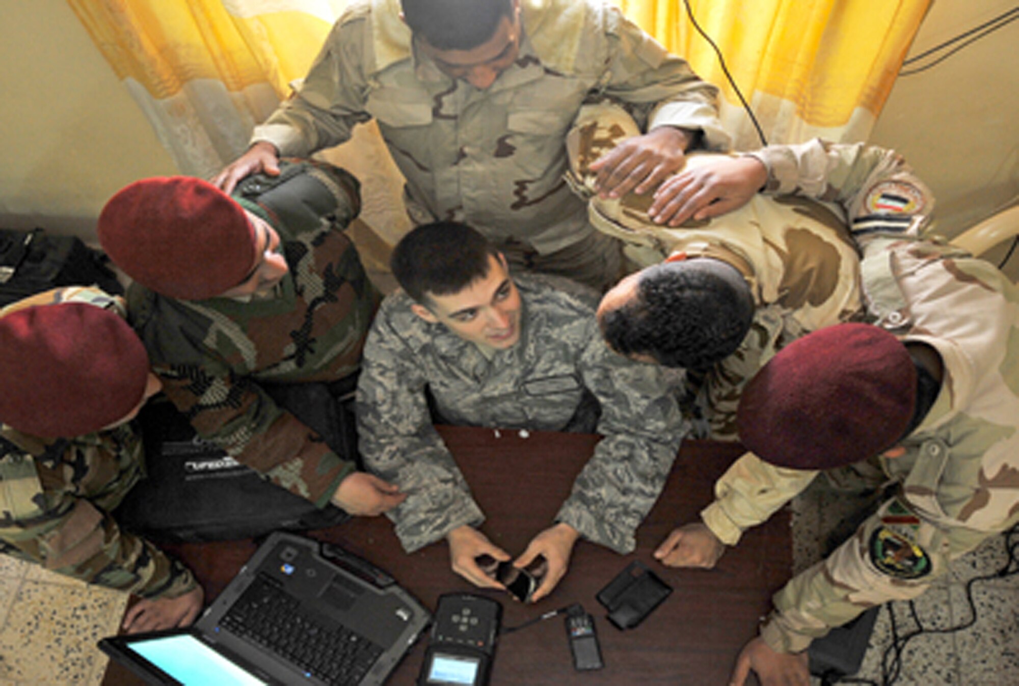 Airman 1st Class Luke Howell shows Iraqi soldiers how to use a CelleBrite machine to gather intelligence from a phone Jan. 5, 2011, on Joint Security Station Constitution, Iraq. Airman Howell is a documentation and media exploitation analyst at Camp Liberty, Iraq. The DOMEX mission is to gather actionable intelligence from documents, electronic devices and other materials collected on the battlefield. (U.S. Air Force photo/Senior Airman Andrew Lee)