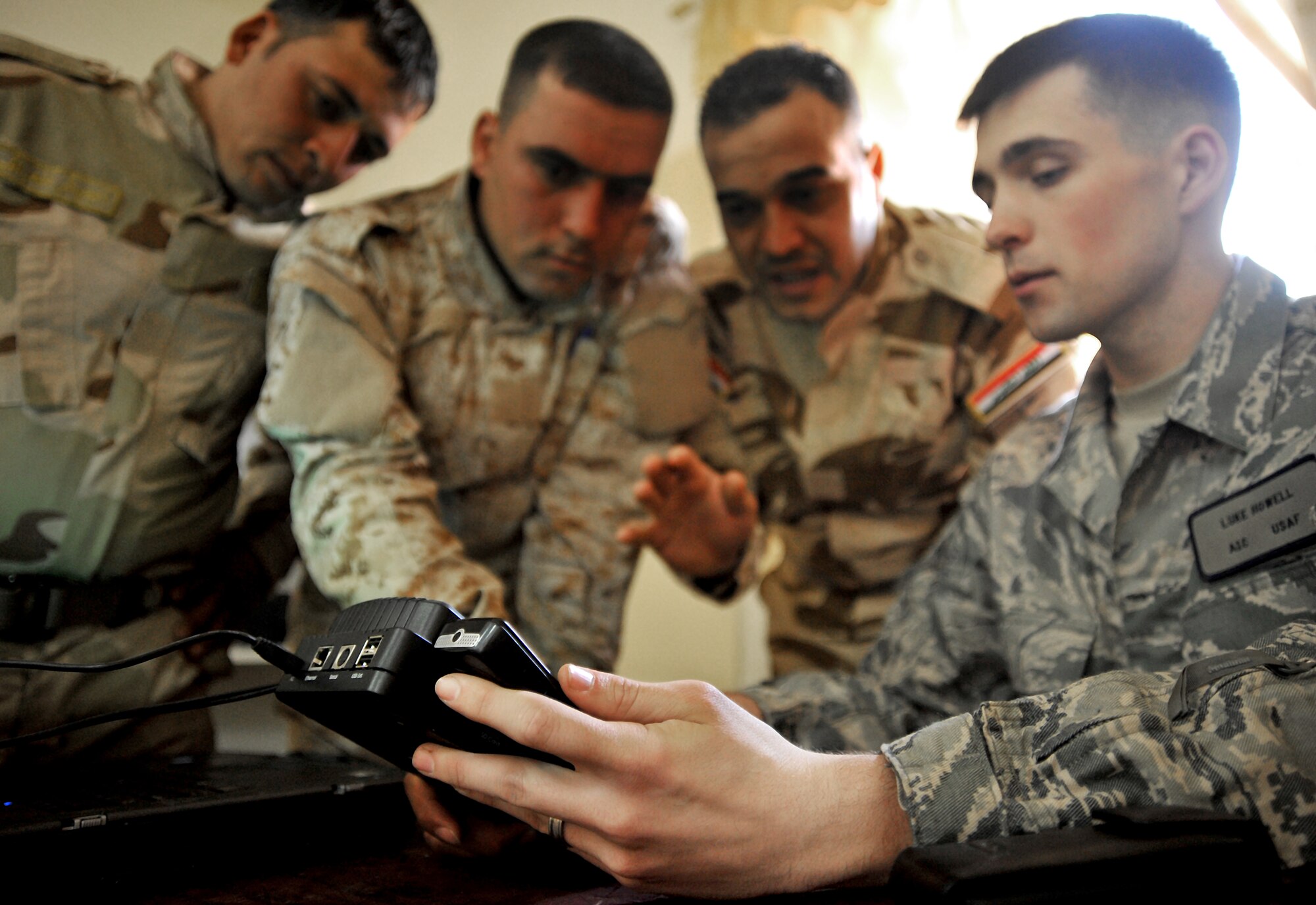 Airman 1st Class Luke Howell shows Iraqi soldiers how to use a CelleBrite machine to gather intelligence from a phone Jan. 5, 2011, on Joint Security Station Constitution, Iraq. Airman Howell is a documentation and media exploitation analyst at Camp Liberty, Iraq. The DOMEX mission is to gather actionable intelligence from documents, electronic devices and other materials collected on the battlefield. (U.S. Air Force photo/Senior Airman Andrew Lee)