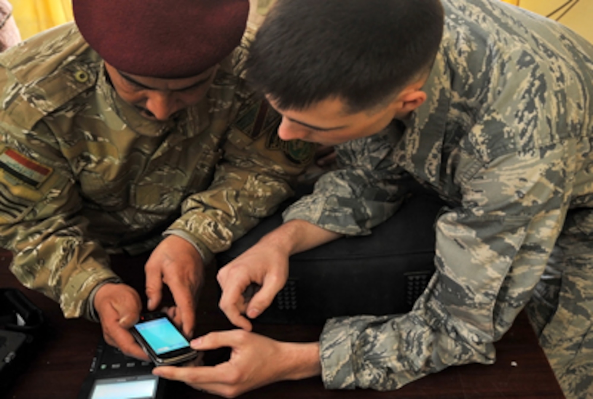 Airman 1st Class Luke Howell shows Iraqi soldiers how to use a CelleBrite machine to gather intelligence from a phone Jan. 5, 2011, on Joint Security Station Constitution, Iraq. Airman Howell is a documentation and media exploitation analyst at Camp Liberty, Iraq. The DOMEX mission is to gather actionable intelligence from documents, electronic devices and other materials collected on the battlefield. (U.S. Air Force photo/Senior Airman Andrew Lee)